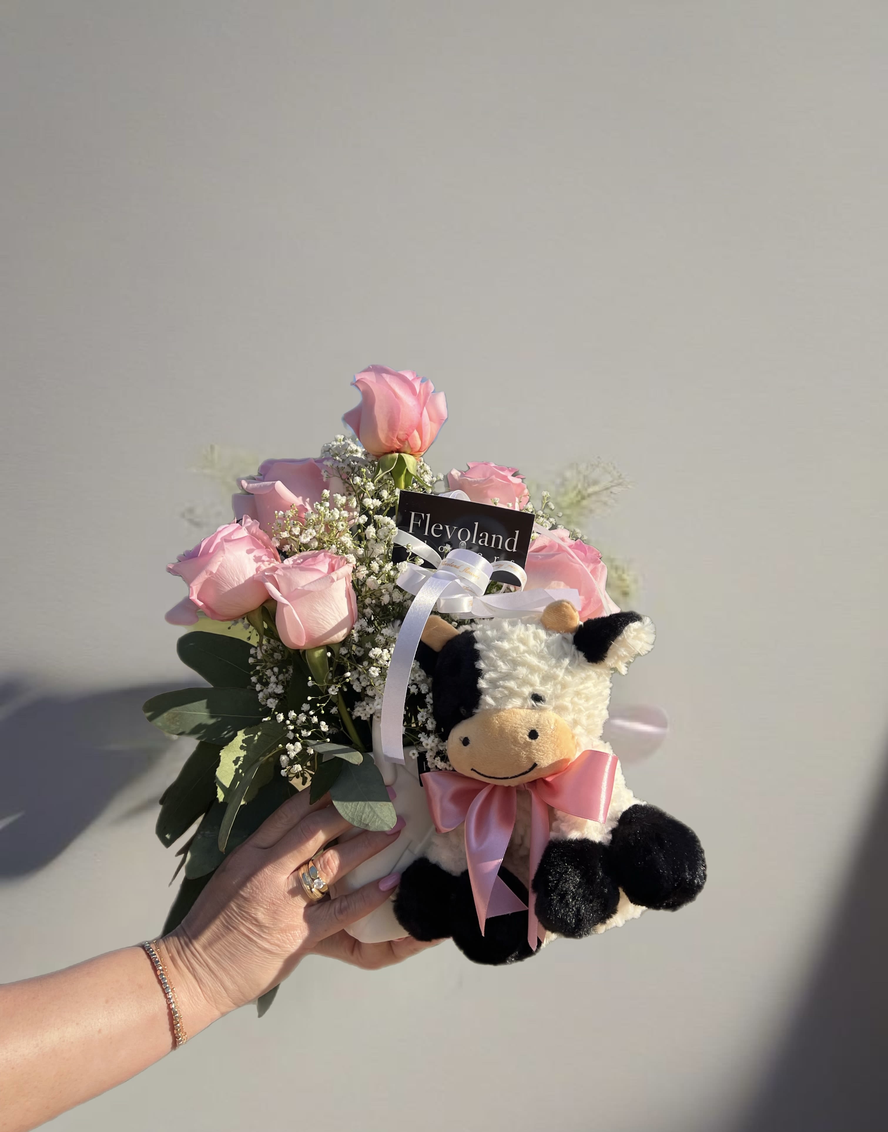 Sweet Welcome - A delicate arrangement featuring soft pink tones, fresh foliage, and a cuddly plush toy—perfect for celebrating the arrival of a new baby. Each detail is thoughtfully selected, using the best available accents to convey love and joy for this special occasion