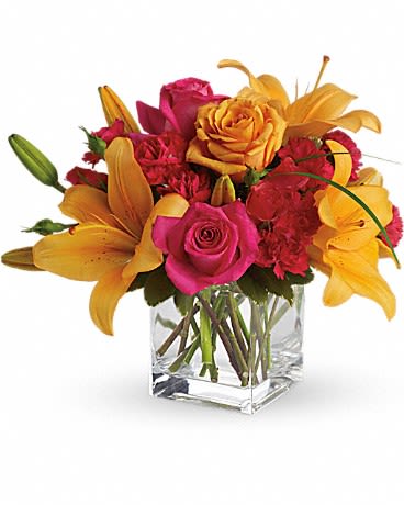 Uniquely Chic - Tres chic! Send that special someone a stylish sentiment with the bright colors of this modern arrangement. Summery hot pinks and oranges are contrasted by the cool clarity of a simple cube vase. An eye-catching everyday choice! Orange asiatic lilies, hot pink and light orange roses, miniature red carnations and a bit of understated greenery. Delivered in a clear glass cube vase. Orientation: All-Around