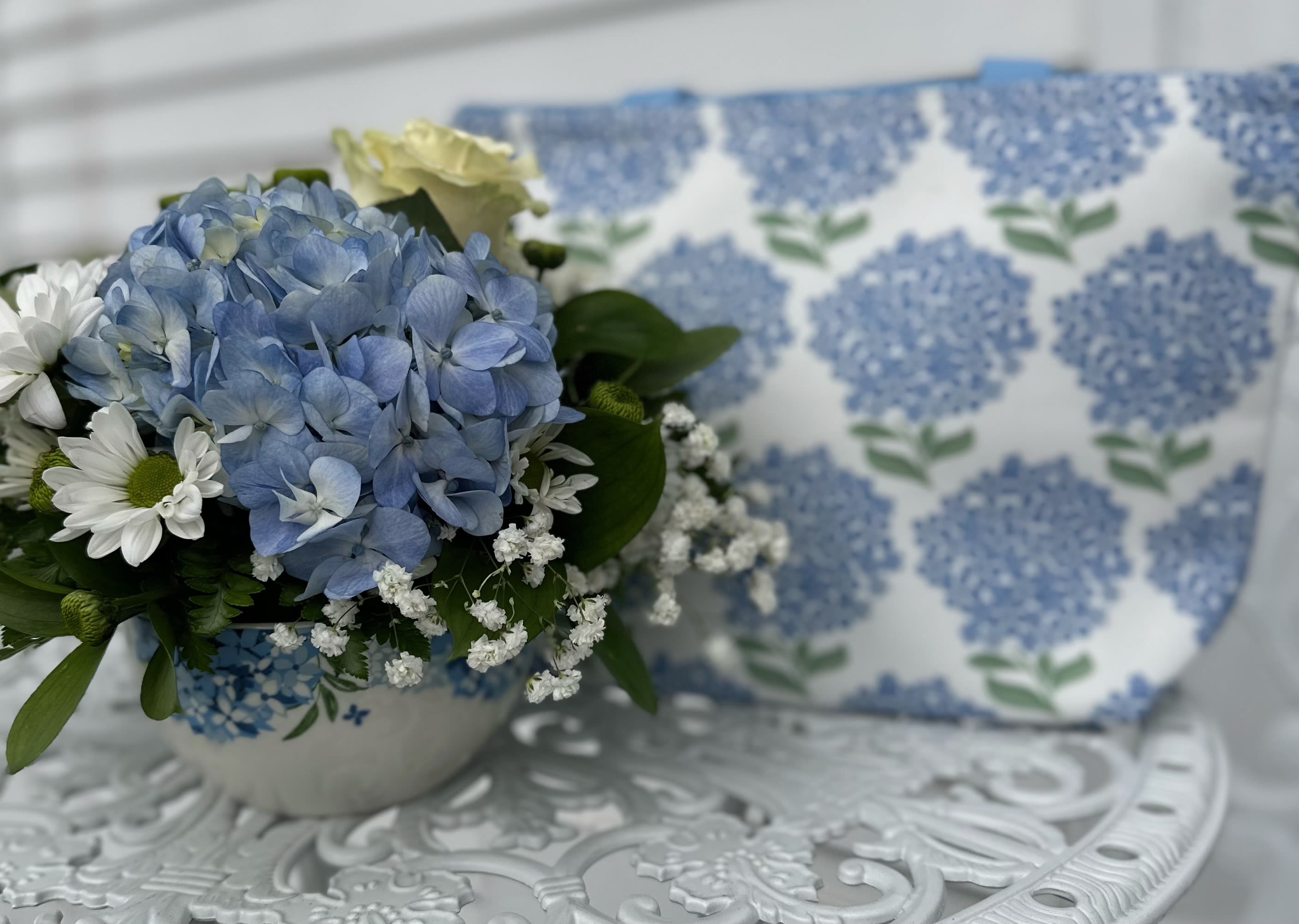 Token of Appreciation Bouquet w/ Lunch Bag - Token of Appreciation Bouquet with hydrangea Lunch Bag Arrangement is designed in a ceramic contaiver with blue hydrangea, White daisys, roses and baby's breath