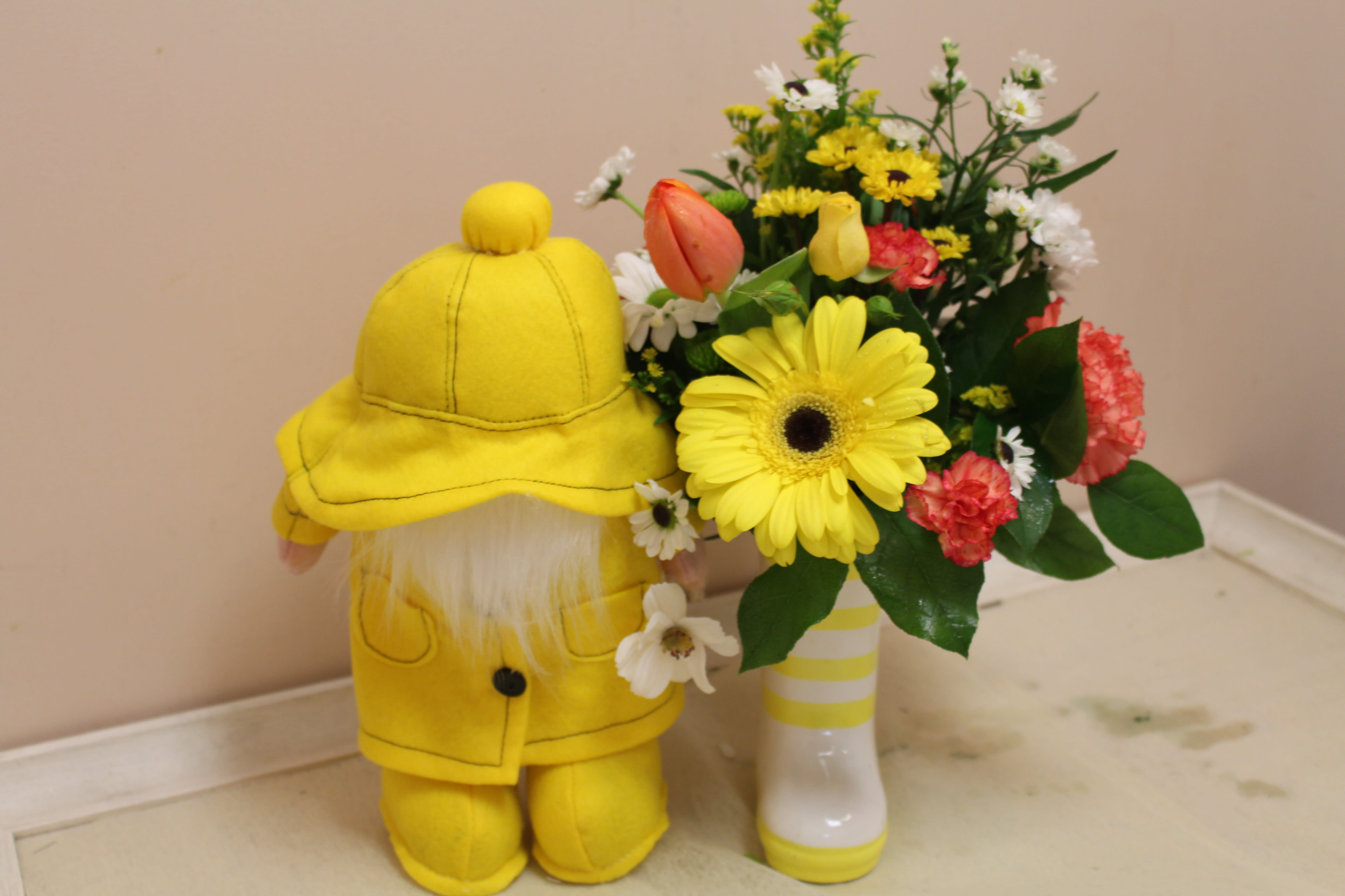 rain showers bring spring flowers  - How cute is this... Spring days are rainy for sure.  This adorable gnome is stuck in the rain with his slicker and yellow boots.  Enjoy this spring arrangement all in a rainboot!!! too cute