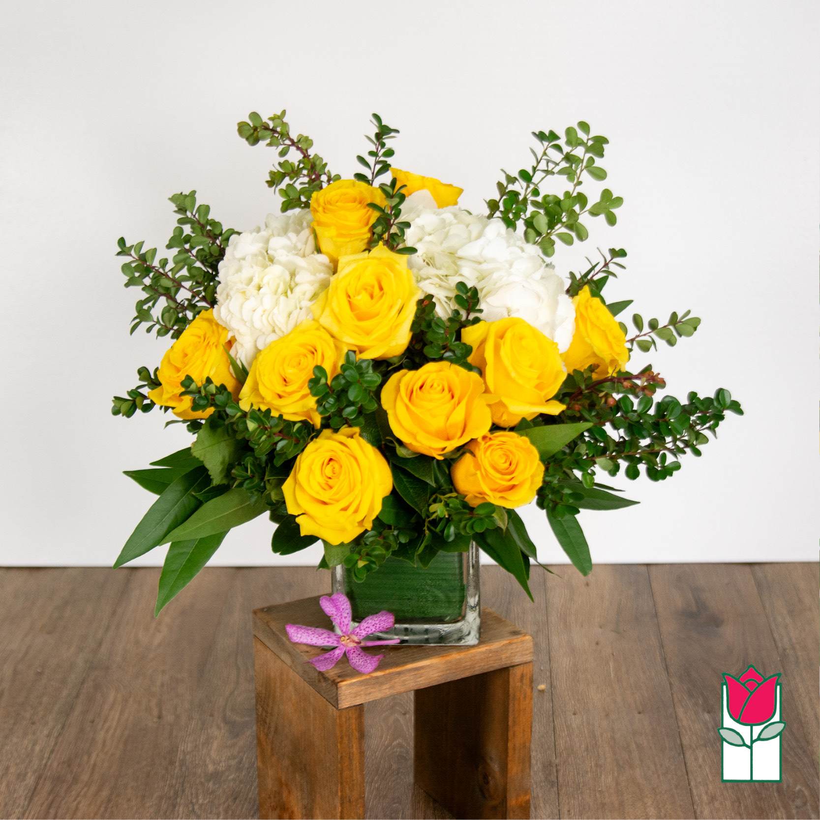 Beretania's Compact Bouquet (Yellow Rose) - Elevate your space with the Beretania Florist Compact Bouquet, a charming floral arrangement that effortlessly combines elegance and versatility. Housed in a beautiful 4&quot; glass cube vase, this compact bouquet features a delightful composition of hydrangeas, foliage, and your choice of roses in various colors, allowing you to tailor it to your preferences.  Whether you opt for the timeless allure of red roses, the soft romance of pink, or the vibrant cheerfulness of yellow, each variant of the compact bouquet brings a unique charm to any setting. The meticulous design ensures a harmonious blend of textures and hues, creating a visually appealing arrangement that suits any occasion.  For those seeking an extra touch of sophistication, consider our upgraded option – the Olivia Compact Bouquet. This variant remains true to the original design but introduces the exotic beauty of colorful cymbidium orchid blossoms, elevating the bouquet to a new level of elegance.  Perfect as a thoughtful gift or a stunning addition to your own space, the Beretania Florist Compact and Olivia Bouquets are crafted with precision and care, promising a burst of floral beauty that suits your style and preferences. Choose the color that speaks to you and let the timeless beauty of these bouquets brighten your day. 