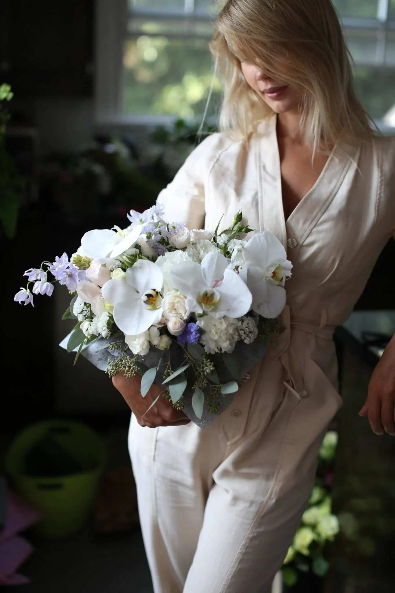 Lucie - Lucie is a white floral composition made of orchids, roses, carnations with some other blooms and eucalyptus. Such kind of compositions are  well suited for any occasion like sympathy, birthday, date and etc. 