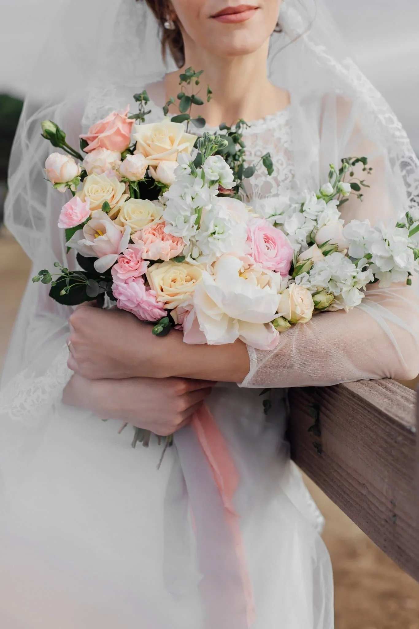 Sally - This stunning wedding bouquet features a mix of soft pastel roses, peonies, tulips, and eucalyptus for a romantic and timeless look. Perfect for a bride seeking a delicate, natural touch on her special day. Flowers may vary slightly based on availability. 