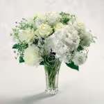 Silver Anniversar y Silver Anniversar y - Pearl-studded hydrangea, white roses, Queen Anne's lace and football mums recall all your years together. Show her that "together" is still where you love to be.
