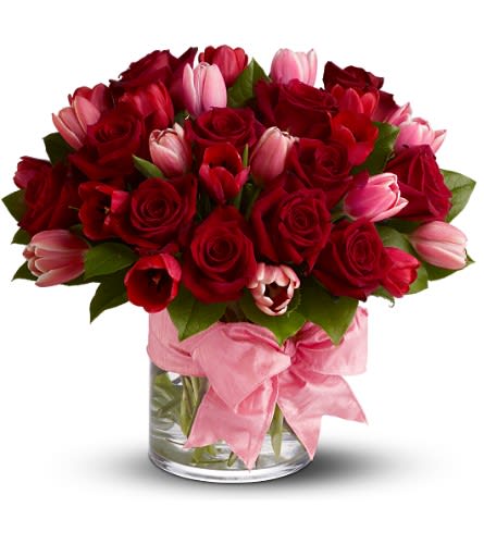 I Love You I Love You - Whisper sweet nothings through petals and blooms with Irvine Village Flowers’ tender love story—a bouquet crafted for hearts entwined. This delicate romance unfurls with a dozen crimson roses, their fragrance a timeless serenade of passion, paired with ten red tulips and ten pink tulips, each a soft sigh of friendship and devotion. Nestled in a sleek glass cylinder vase and adorned with a grand pink satin ribbon, this arrangement is a gentle embrace in floral form, a magnificent gift to stir the soul. Each flower carries a lover’s promise: the crimson roses, bold and velvety, speak of deep, unspoken romance, their rich hue a heartbeat made visible. Red tulips bloom with perfect love, a quiet vow of forever, while the pink tulips, fragile and sweet, weave in threads of affection and unwavering loyalty. Together, they dance in harmony, a delicate symphony of adoration and grace. From Irvine Village Flowers, this treasure is perfect for confessing “I love you” to your soulmate. Visit us in-store or online, and let our seamless delivery bring this romantic reverie to their door, fresh and blooming with your heart’s truest song.