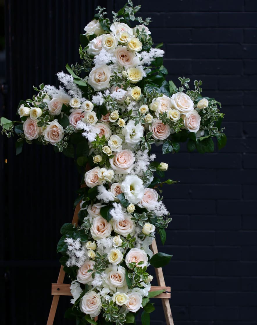 Rest in peace - A solemn tribute featuring roses and lisianthus arranged in the shape of a cross. A symbol of faith, love, and remembrance, perfect for memorials and funerals.