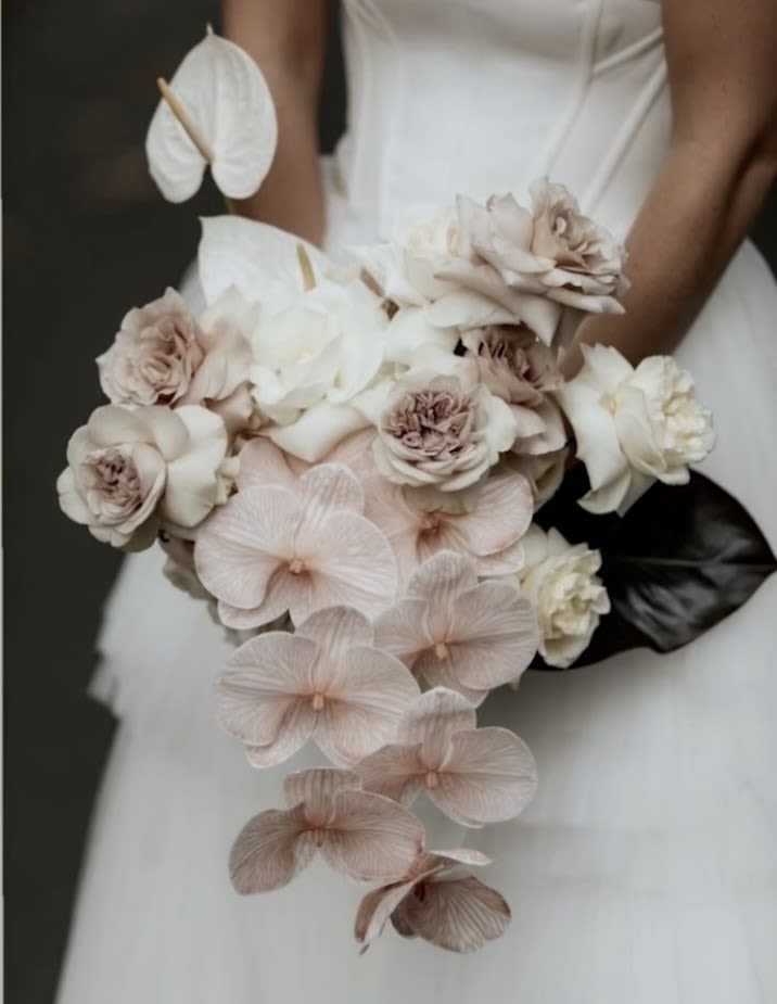 Modern Luxury Bridal Bouquet  - Make a breathtaking statement on your wedding day with this modern luxury bridal bouquet, featuring an ethereal blend of soft nude orchids, creamy white roses, and delicate anthuriums. Designed for the modern bride, this cascading arrangement exudes sophistication, grace, and contemporary elegance.   Premium orchids, garden roses, and exotic anthuriums for a unique, stylish look  Perfect for modern, minimalist, and high-fashion bridal aesthetics  A stunning choice for weddings, elopements, and bridal photoshoots  Hand-tied with luxurious ribbon for a refined, couture finish  Custom bridal bouquet design and delivery in Los Angeles  Elevate your wedding with this exquisite luxury floral creation. 