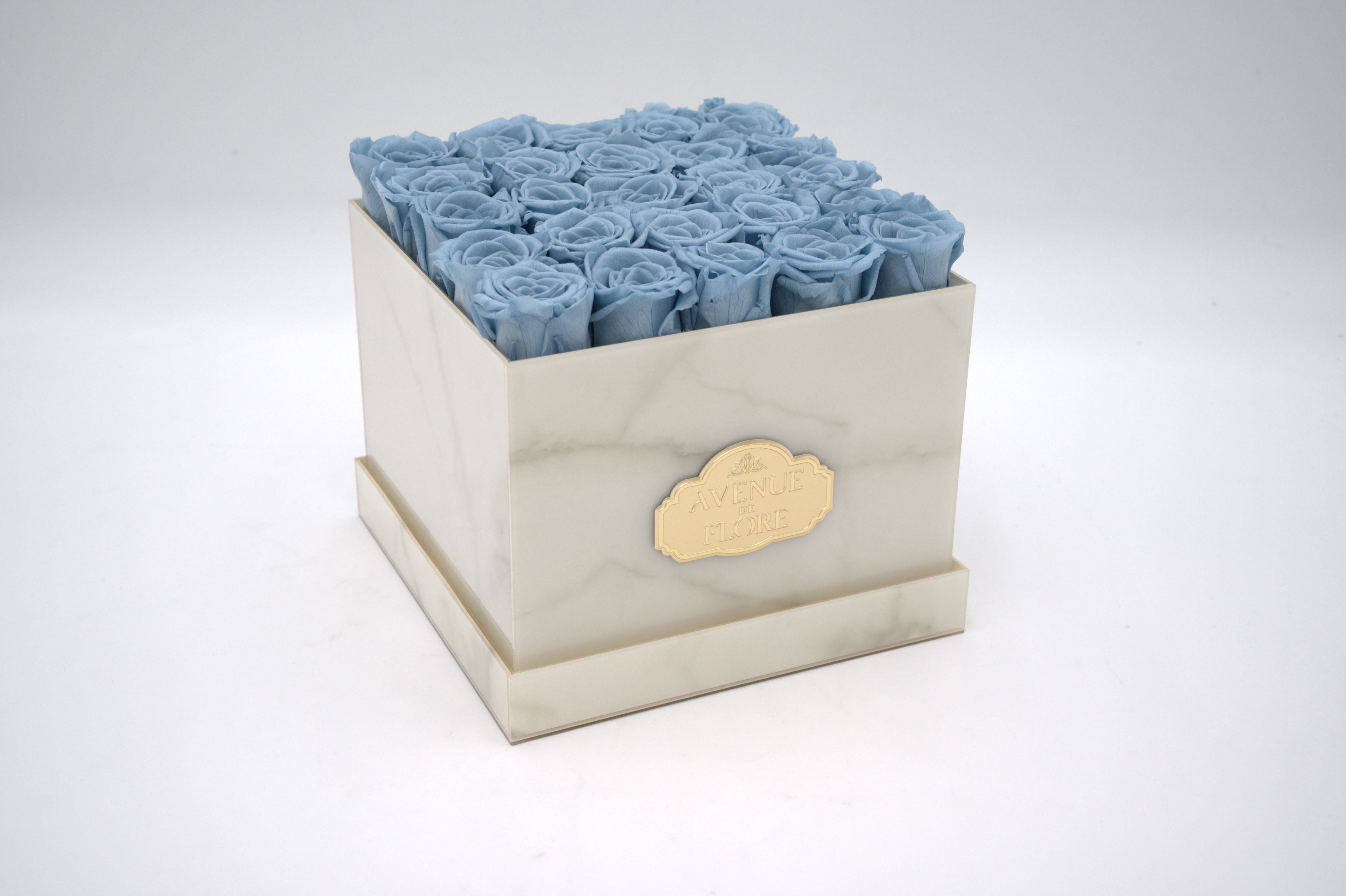White Marble Square Box - Blue Eternal Roses White Marble Square Box - Blue Eternal Roses - Discover timeless elegance with our exquisite White Marble box adorned with 25 blue roses. The sleek white marble exterior enhances any space, while the meticulously crafted blue roses gracefully last for years in all their magnificence. Perfect as a unique gift or a statement piece for your home decor. NOTE: The shade and size of blue roses may vary slightly from the image, depending on availability. PRESERVED ROSES.