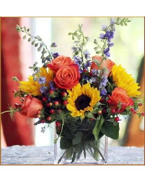 Sunrise Bouquet Sunrise Bouquet - This beautiful arrangement of sunflowers, orange roses and purple larkspur with hypericum berries in a glass cube vase is sure to put a smile on their face. Due to the unique nature and variety of selected flowers, colors may vary and items may be substituted as needed to complete the beauty of this selection.