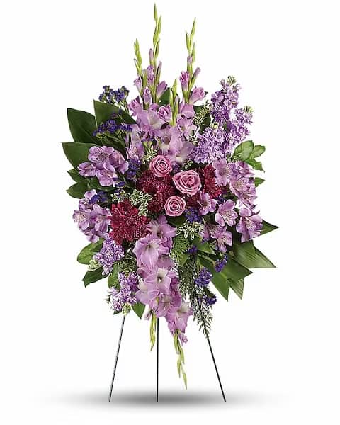 Lavender Reflections Spray - Console and comfort with this luxurious spray of lavender roses, alstroemeria and gladioli. It's a majestic way to remember the departed at the memorial service. This regal spray includes lavender roses, lavender alstroemeria, lavender gladioli, lavender stock, purple cushion spray chrysanthemums, purple sinuata statice, green ti leaves, flat cedar, oregonia and lemon leaf.  