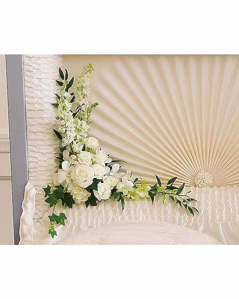 Moonlit Walk - This serenely beautiful arrangement of white orchids, white roses and other popular white flowers is a fitting and very personal tribute when placed inside the casket. The magnificent bouquet includes white dendrobium orchids, white roses, white spray roses, a white carnation and white larkspur, accented with assorted greenery.