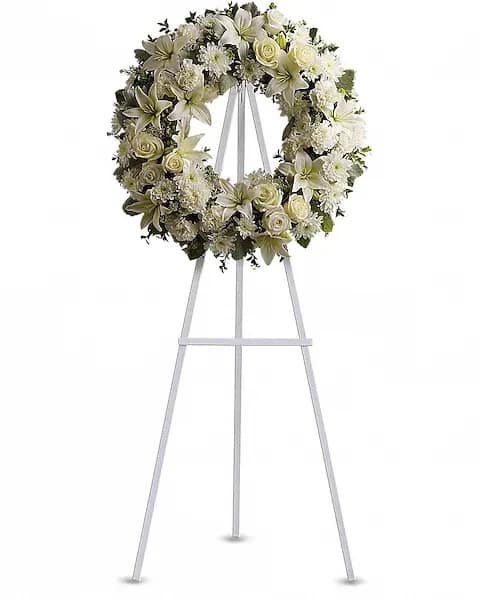 Serenity Wreath - A ring of fragrant, bright white blossoms will create a serene display at any funeral or wake. This classic wreath is delivered on an easel, and is a thoughtful expression of sympathy and admiration. A standing wreath created from fresh white flowers such as roses, Asiatic lilies, carnations and cushion spray chrysanthemums - accented with greenery - is delivered on an easel.  