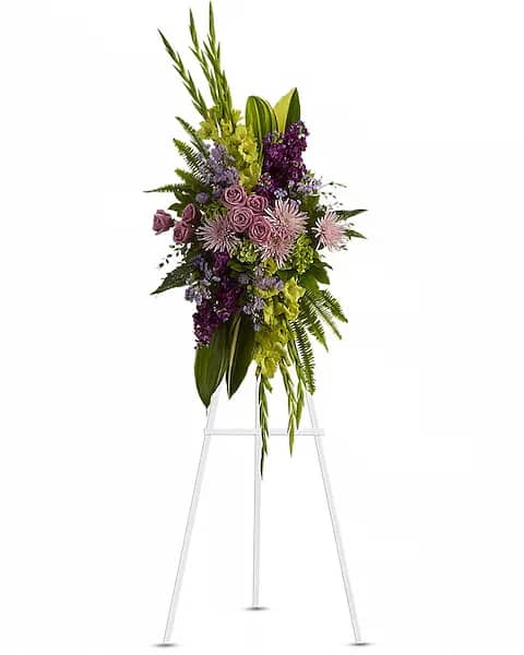 The Endless Sky Standing Spray - Lavender blooms and lush velvet greenery evoke a celebration of a life well lived. A lovely mix of flowers such as lavender roses, chrysanthemums, statice and asters are beautifully complemented by glossy green aspidistra leaves, fern and fragrant eucalyptus.  