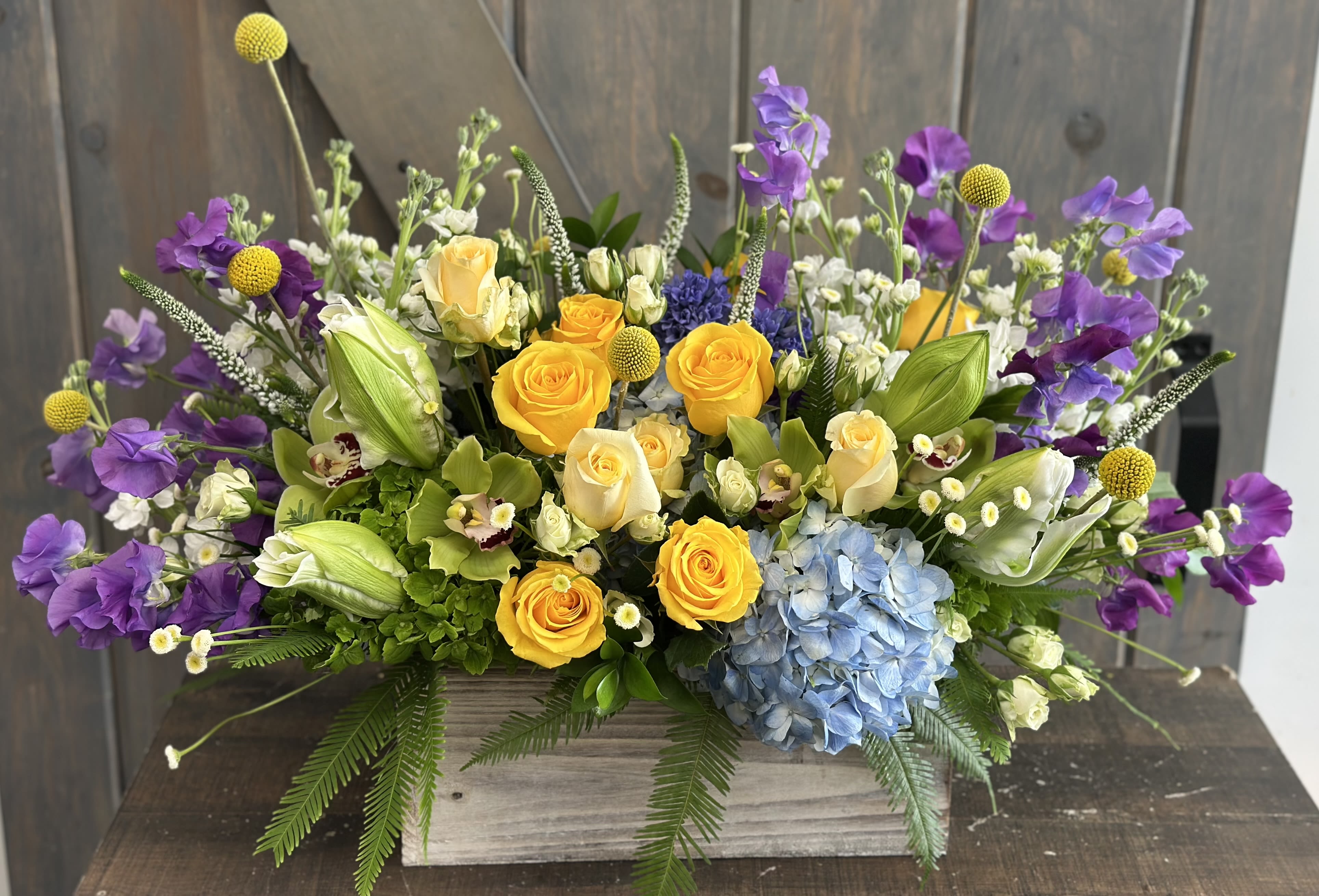 Spring is in the Air - All the blooms spring offers in a beautiful boxed display. Arrangement includes Roses, Spray Roses, Hydrangea, Rose Lilies, Stock, Veronica, Sweet Peas, Hyacinth, Billy Balls, Cymbidium Orchids and Umbrella Fern