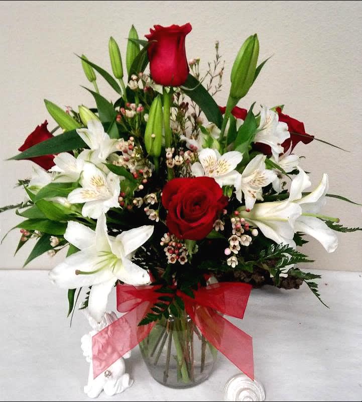 Love is in The Air - When the Occasion Arises secure the moment with this gorgeous assortment of Pure White Lilies, White Alstroemeria, Red Ecuadorian Roses and Wax flower with a tidy bow.