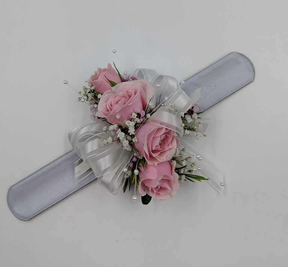 Traditional Pink Rose Corsage - Soft pink roses combine with white ribbons to make this simple and elegant wrist corsage. Shown with slap wristlet band.