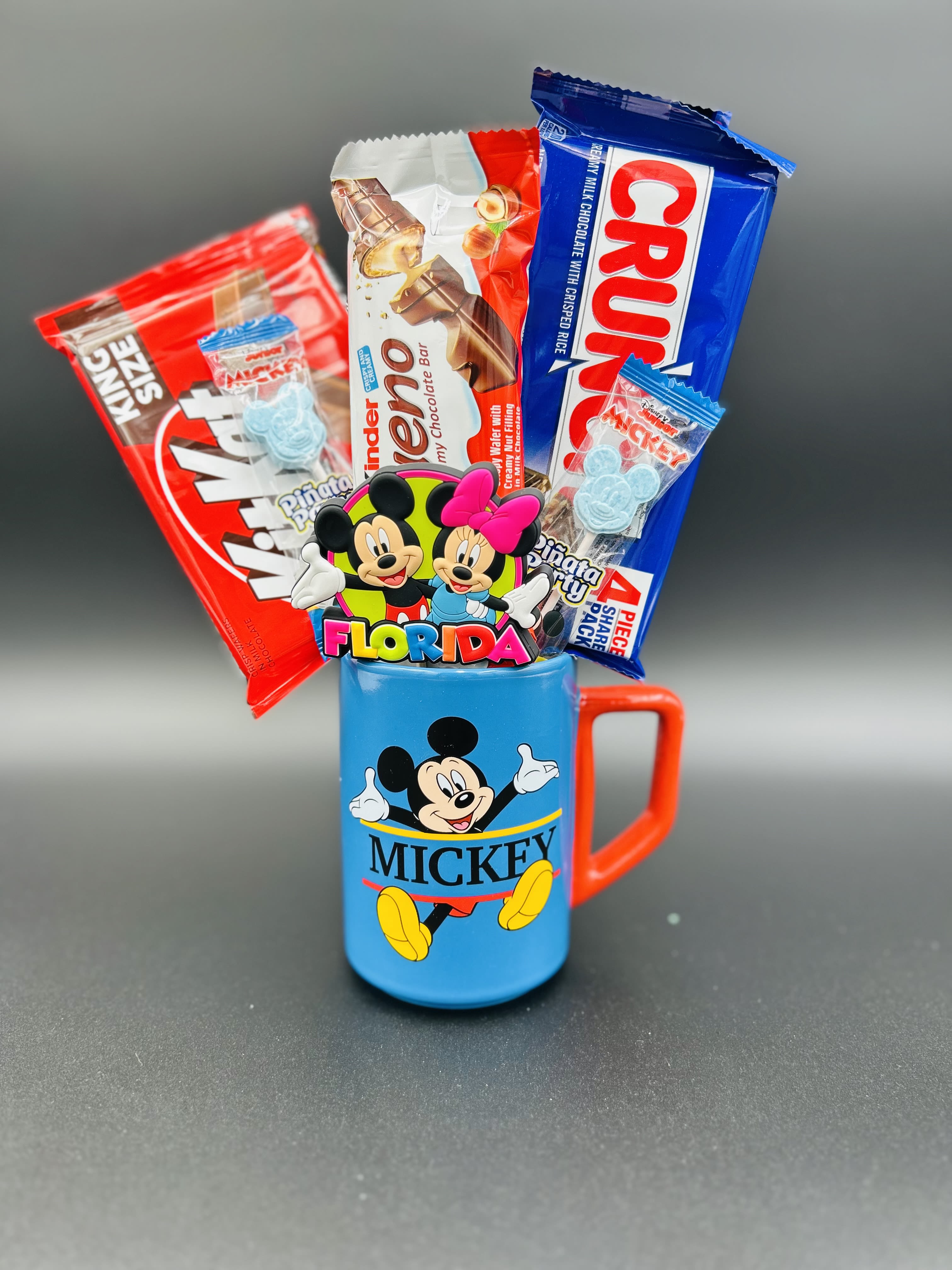 A Disney Mickey Mug - Adorable gift arrangement,  mug accompanied by a variety of chocolates and candies.