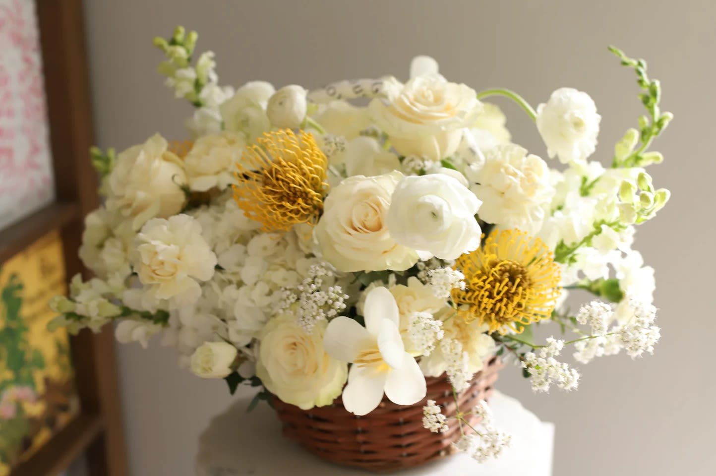 Mom’s Blooming Joy - For the mom whose joy makes everything bloom. Introducing Mom’s Blooming Joy  — a radiant basket arrangement that celebrates the vibrant, nurturing energy of a joyful mother.  This design features a fresh palette of creamy whites, soft ivories, and golden accents — with garden roses, ranunculus, hydrangeas, snapdragons, and striking yellow pincushions. Textural and light, the florals are arranged in a charming woven basket, blending natural elegance with cheerful sophistication.  Warm, graceful, and full of light, Mom’s Blooming Joy is a tribute to the happiness she brings to every room and every heart.    Dimensions: Height: 38 cm (15 inches) Width: 40 cm (16 inches)   Available now for limited pre-orders with delivery in Miami’s neighborhoods.  #MomsBloomingJoy #LuxuryFlorals #MothersDayGift #BloomWithLove #RusticChic #MiamiFlorist #JoyfulFlowers 