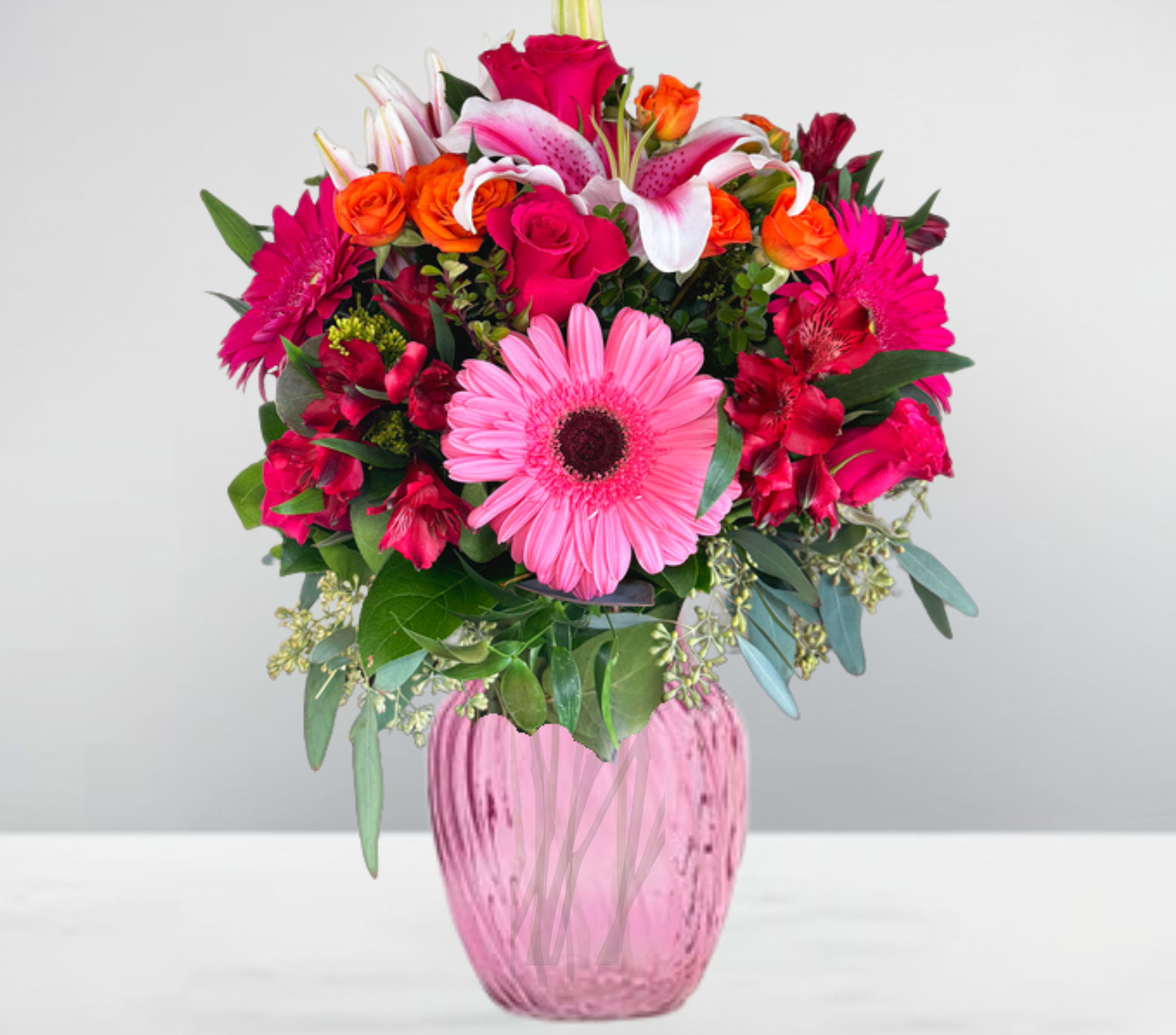 Rosy sunset Rosy sunset - Rosy Sunset is a breathtaking floral arrangement that captures the warmth and brilliance of a sunset in full bloom. At its heart, lush pink Gerbera daisies radiate charm, while striking Stargazer lilies add a touch of elegance with their bold, fragrant petals. Accents of vibrant orange spray roses and deep red Alstroemeria weave together a stunning contrast, symbolizing passion and joy. Arranged in a delicate pink vase, this bouquet exudes warmth, romance, and a hint of sunset magic—perfect for brightening any space or celebrating life’s special moments.