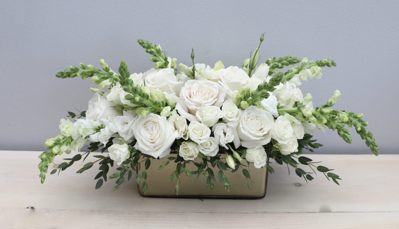 Gold Whym - LA - One of our newest creations. Roses, spray roses, and huck green arranged just right in our new gold rectangular ceramic vases. Great for any occasion and will make a statement on any table.  The standard version (photo) is approximately 12'' tall and 20'' wide. 