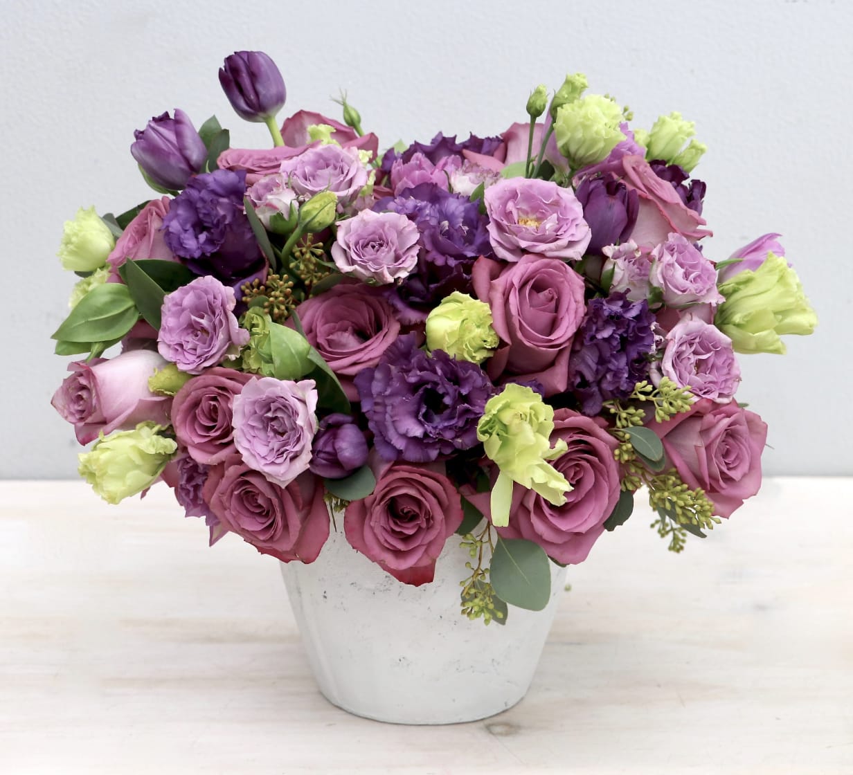 Purple Beauty - LA - Roses, lisanthus and seasonal greens from Glendale Florist. Approximately 14'' in diameter and height for the standard version. 50% larger with each upgrade. This wild design celebrates the diversity of nature and it makes the perfect gift for someone who really appreciates the variety of life. 