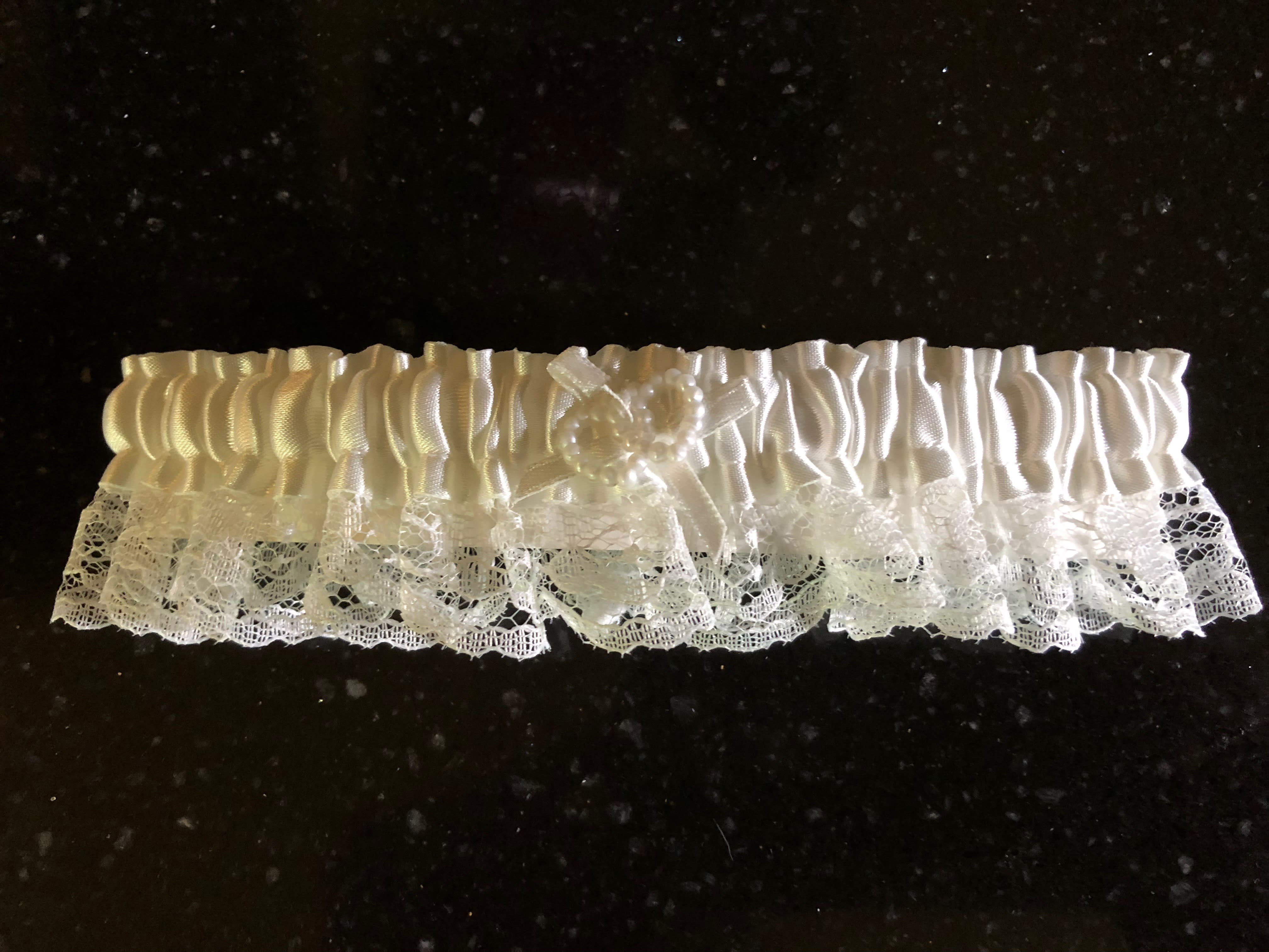 White garter - Lacy white garter with white ribbon, with a small beaded heart charm.