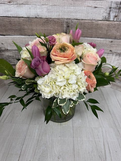 Blushing Blooms - Bushing Blooms is a lush floral arrangement that bursts with natural beauty, inspired by the wild, untamed elegance of flowering shrubs in full bloom. This design features an abundant mix of delicate blossoms and textured greenery, artfully arranged to create a soft, overflowing silhouette. 