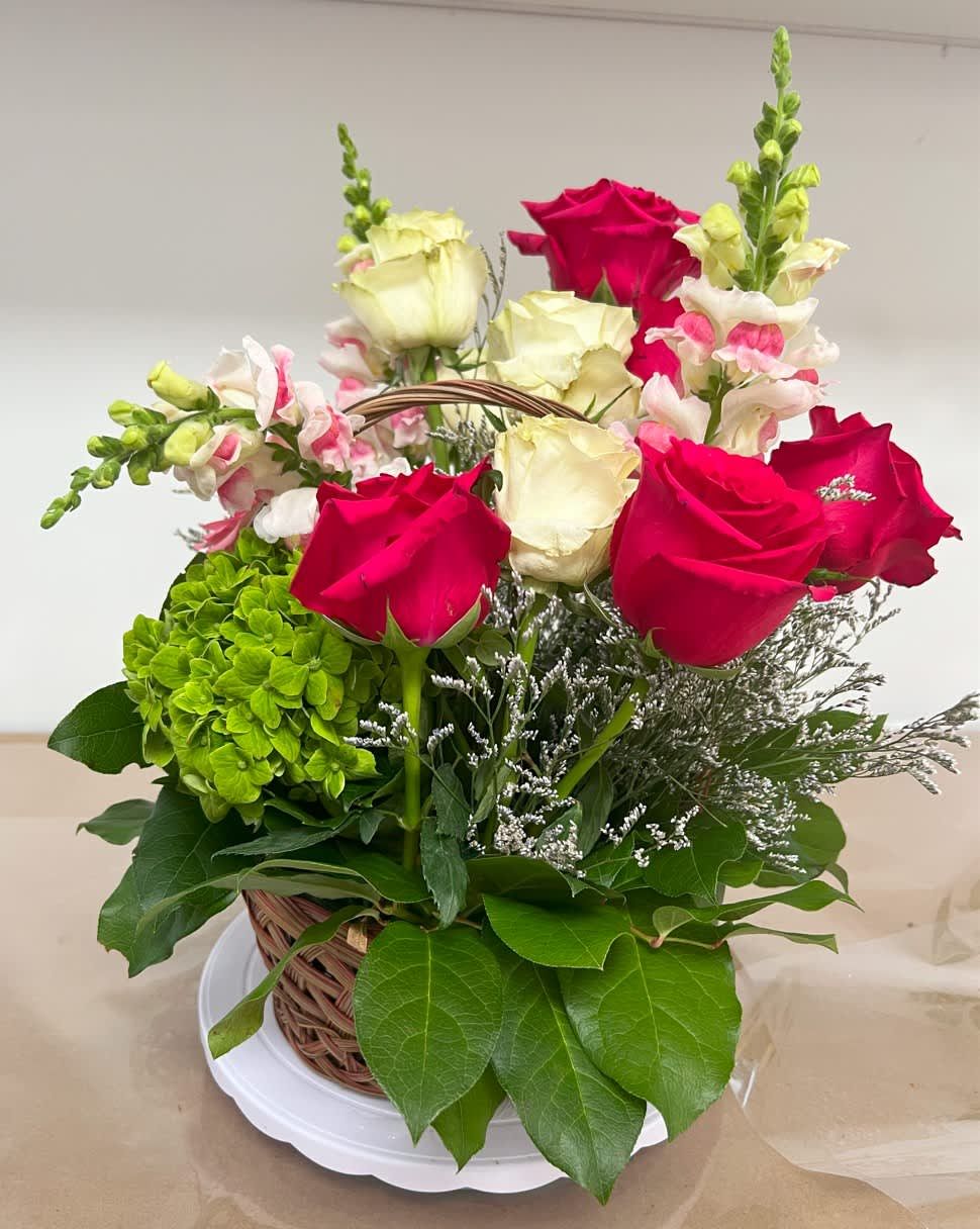 Roses, Snapdragon, and Hydrangeas Arrangement Roses, Snapdragon, and Hydrangeas Arrangement - Arrangement in a medium basket with red and white roses, 4 snapdragons, hydrangeas (white or green), lemon leaves, and lavender.
