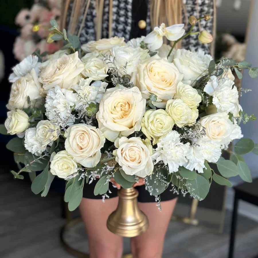 Endless Love Centerpiece - Make your special day unforgettable with our Endless Love Centerpiece. This exquisite arrangement, featuring the pristine beauty of white roses, the vibrant charm of yellow roses, and the purity of white carnations, creates a stunning focal point that embodies elegance and love. Perfect for adding a touch of grace to your wedding or engagement celebration.