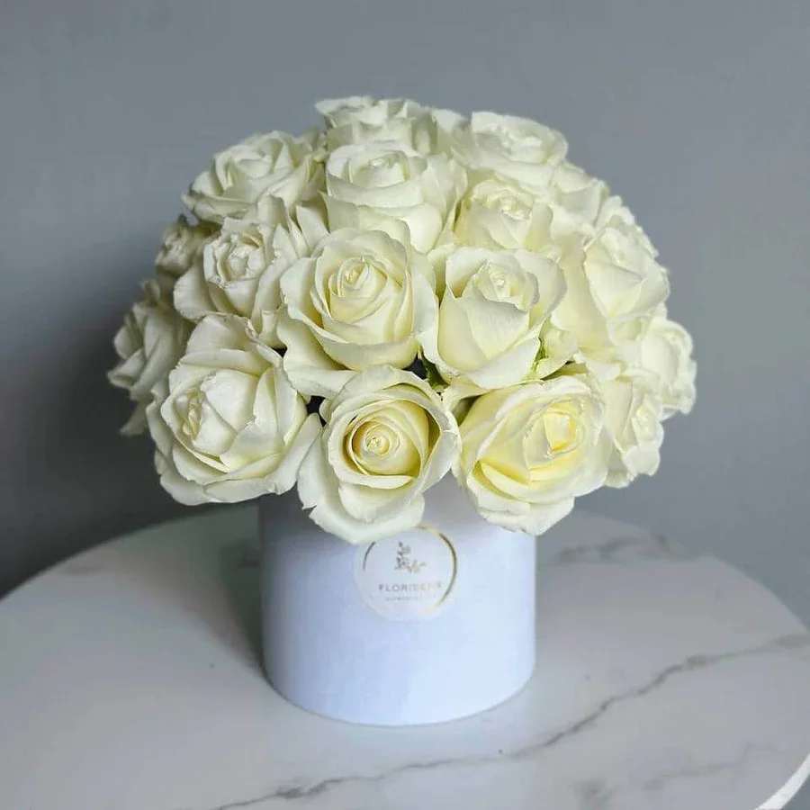 Snowball - Snowball is a breathtaking arrangement, featuring pristine white roses elegantly arranged in a beautiful box. This luxurious ensemble exudes sophistication and timeless beauty, making it the perfect gift for any special occasion or a stunning addition to your space.