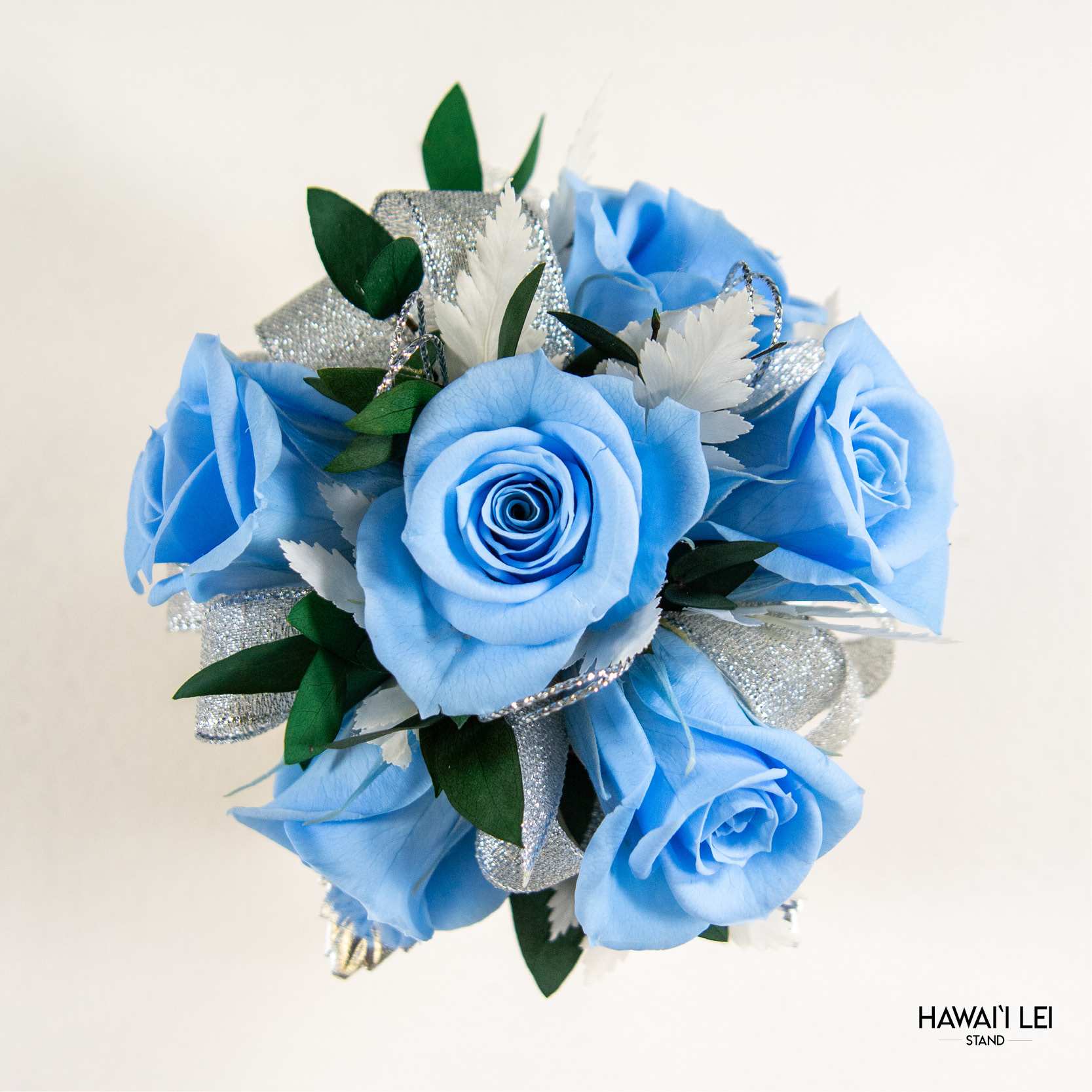 [Call To Order] Beretania's Wrist Corsage - Forever Rose (Premium - Blue) - Elevate your prom, wedding, or special event ensemble with the exquisite Forever Rose Wrist Corsage from the Hawaii Lei Stand by Beretania Florist. Crafted to perfection, this stunning accessory is a timeless addition to any formal occasion.  Available in a variety of captivating rose colors, our Forever Rose Wrist Corsage offers unparalleled elegance and versatility. Whether you prefer classic red, delicate pink, vibrant white, blue, yellow and lavender there's a shade to complement every style and aesthetic.  What sets this corsage apart is its longevity. Unlike wrist corsages made with fresh roses, our Forever Rose Wrist Corsage features preserved roses, ensuring that its beauty endures for years to come with proper care. Imagine cherishing the memory of your special day as you preserve this exquisite corsage as a timeless keepsake.  To maintain the beauty of your Forever Rose Wrist Corsage, keep it away from direct sunlight and refrain from storing it in the refrigerator. Additionally, ensure it remains dry to prolong its lifespan and retain its stunning appearance.  Make a lasting impression at your next event with the Forever Rose Wrist Corsage from Hawaii Lei Stand by Beretania Florist. Embrace elegance and create cherished memories that will be treasured for a lifetime.