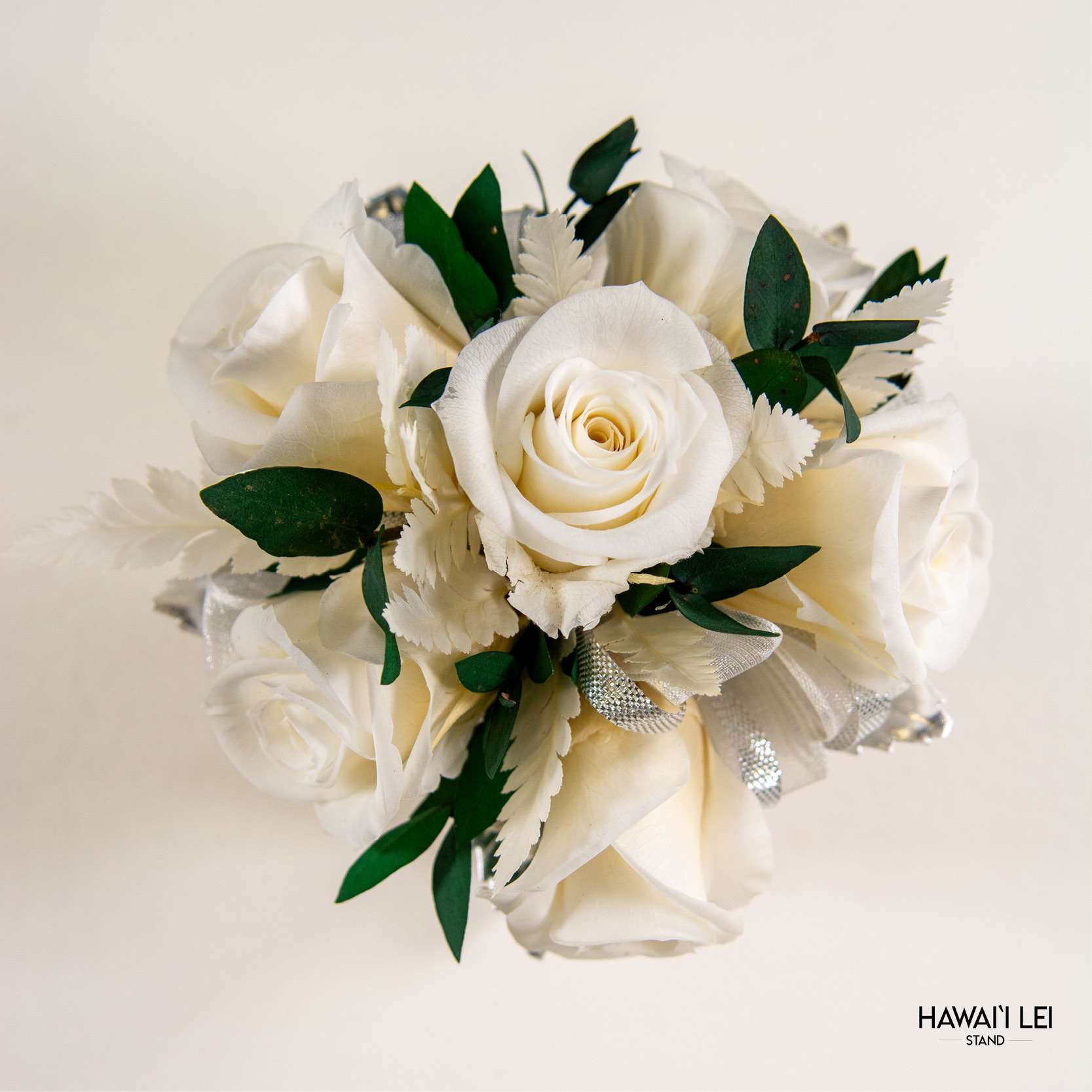 [Call To Order] Beretania's Wrist Corsage - Forever Rose (Premium - White)  - Elevate your prom, wedding, or special event ensemble with the exquisite Forever Rose Wrist Corsage from the Hawaii Lei Stand by Beretania Florist. Crafted to perfection, this stunning accessory is a timeless addition to any formal occasion.  Available in a variety of captivating rose colors, our Forever Rose Wrist Corsage offers unparalleled elegance and versatility. Whether you prefer classic red, delicate pink, vibrant white, blue, yellow and lavender there's a shade to complement every style and aesthetic.  What sets this corsage apart is its longevity. Unlike wrist corsages made with fresh roses, our Forever Rose Wrist Corsage features preserved roses, ensuring that its beauty endures for years to come with proper care. Imagine cherishing the memory of your special day as you preserve this exquisite corsage as a timeless keepsake.  To maintain the beauty of your Forever Rose Wrist Corsage, keep it away from direct sunlight and refrain from storing it in the refrigerator. Additionally, ensure it remains dry to prolong its lifespan and retain its stunning appearance.  Make a lasting impression at your next event with the Forever Rose Wrist Corsage from Hawaii Lei Stand by Beretania Florist. Embrace elegance and create cherished memories that will be treasured for a lifetime.