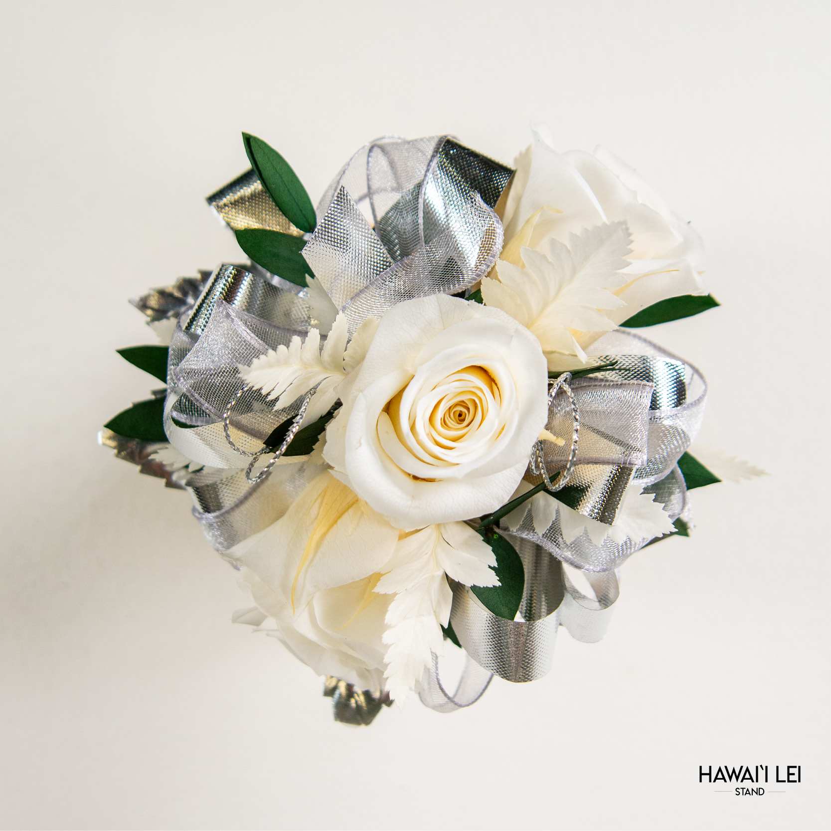 [Call To Order] Beretania's Wrist Corsage - Forever Rose (Classic - White) - Elevate your prom, wedding, or special event ensemble with the exquisite Forever Rose Wrist Corsage from the Hawaii Lei Stand by Beretania Florist. Crafted to perfection, this stunning accessory is a timeless addition to any formal occasion.  Available in a variety of captivating rose colors, our Forever Rose Wrist Corsage offers unparalleled elegance and versatility. Whether you prefer classic red, delicate pink, vibrant white, blue, yellow and lavender there's a shade to complement every style and aesthetic.  What sets this corsage apart is its longevity. Unlike wrist corsages made with fresh roses, our Forever Rose Wrist Corsage features preserved roses, ensuring that its beauty endures for years to come with proper care. Imagine cherishing the memory of your special day as you preserve this exquisite corsage as a timeless keepsake.  To maintain the beauty of your Forever Rose Wrist Corsage, keep it away from direct sunlight and refrain from storing it in the refrigerator. Additionally, ensure it remains dry to prolong its lifespan and retain its stunning appearance.  Make a lasting impression at your next event with the Forever Rose Wrist Corsage from Hawaii Lei Stand by Beretania Florist. Embrace elegance and create cherished memories that will be treasured for a lifetime.