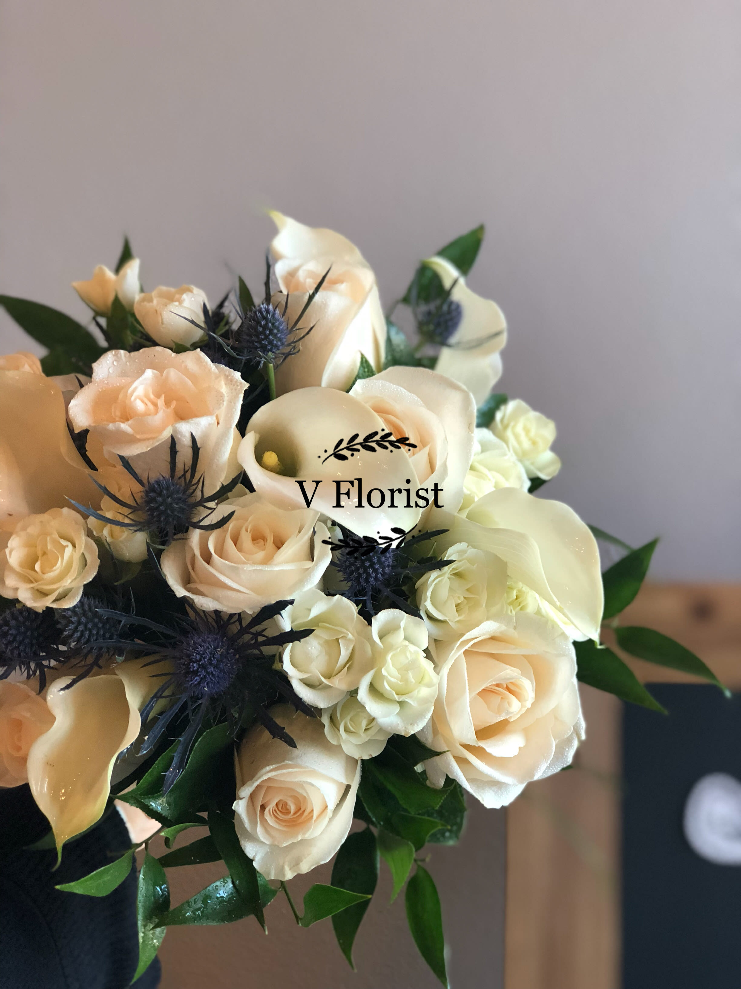 All White Bouquet (style 3) - On your wedding day, nothing is more classic or elegant than an all-white bouquet. We’ve filled ours with White roses, white calla lilies and white spray roses finished it off with a matching white satin ribbon. Beautifully hand-arranged by our team of expert florists, it’s as perfect a pairing as the happy couple. Stunning hand-designed bouquet of white roses, white calla lilies and white spray roses accented with a crisp white satin ribbon All of our wedding flowers are hand-designed and arranged at a local florist to ensure they arrive looking their best on the big day Our florists select the freshest flowers available so floral colors and varieties may vary Orders must be placed two weeks in advance to allow for processing