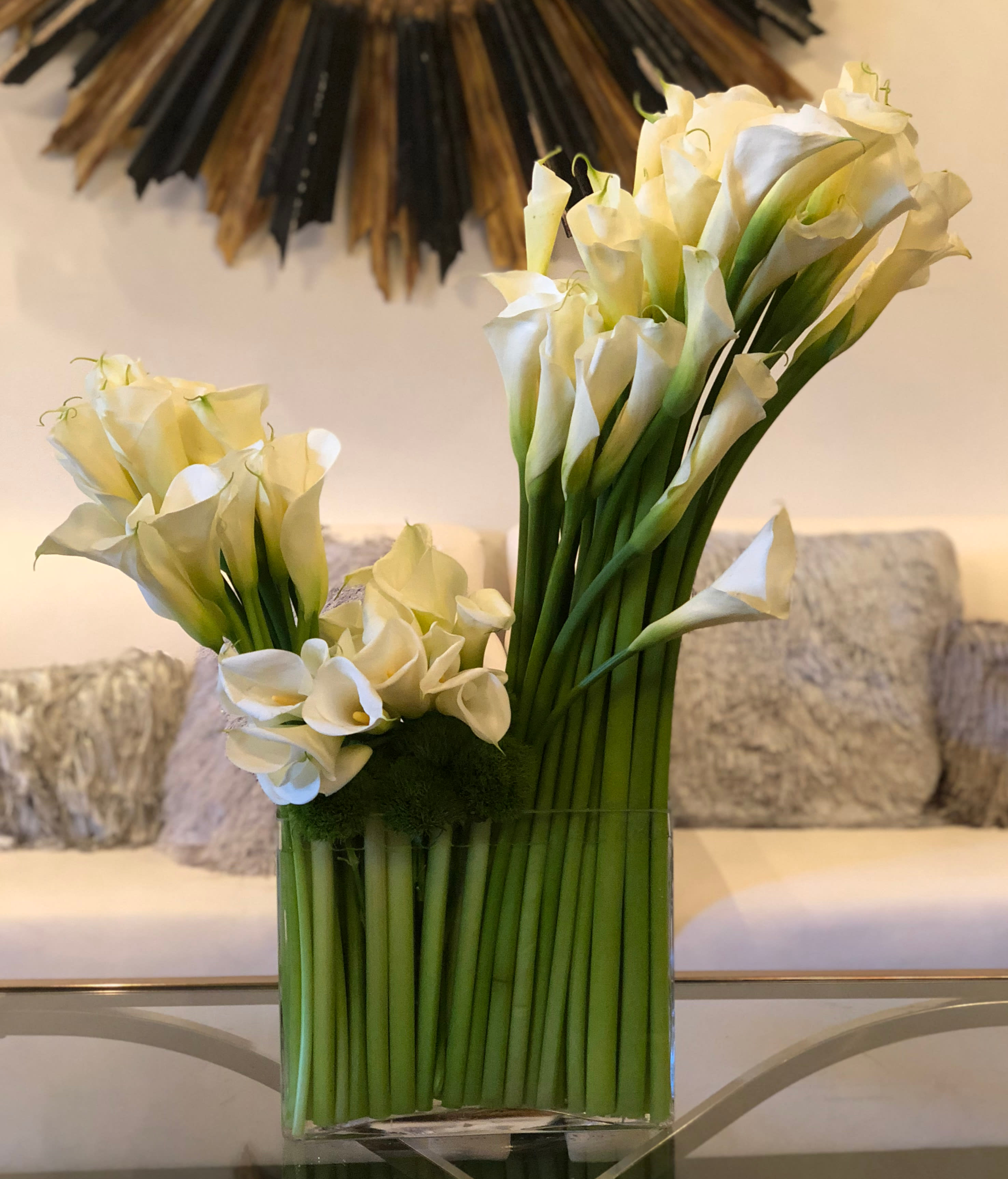 Don't Be Callas! - A large arrangement with a beautifully sculptured swoop of Calla Lillies and greens. It will be a perfect arrangement for a discerning eye and fan of modern drama.