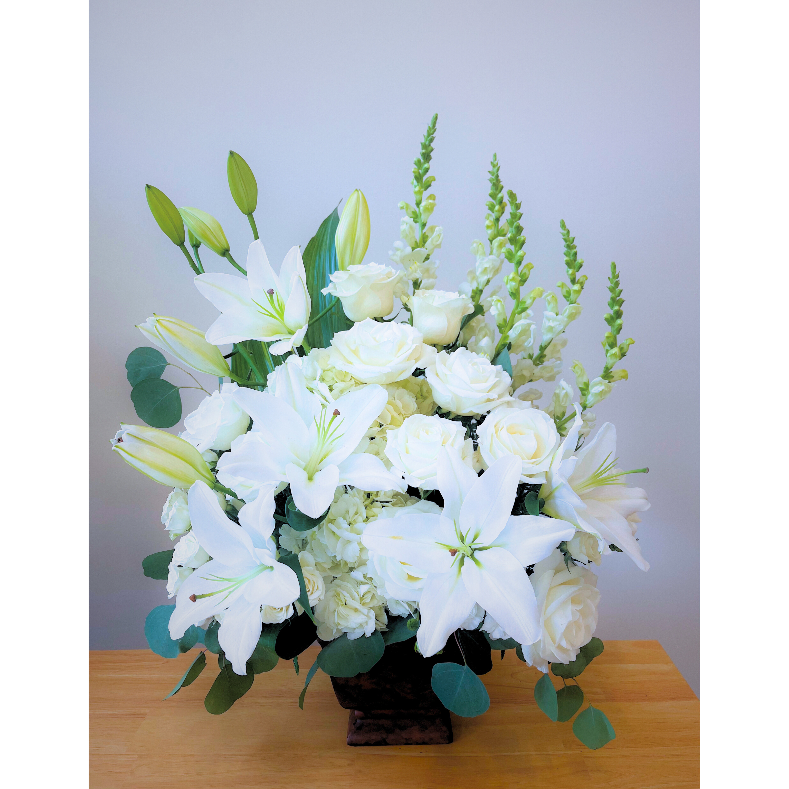 Peaceful Journey - Peaceful Journey&quot; is a serene and elegant floral arrangement, featuring pure white roses, lilies, and carnations thoughtfully arranged in a graceful vase. Each delicate bloom symbolizes purity, love, and remembrance, offering a tranquil tribute to a loved one. The soft white tones bring a sense of calm and serenity, creating a comforting presence for those honoring their loss. A timeless and respectful way to express sympathy and peace.
