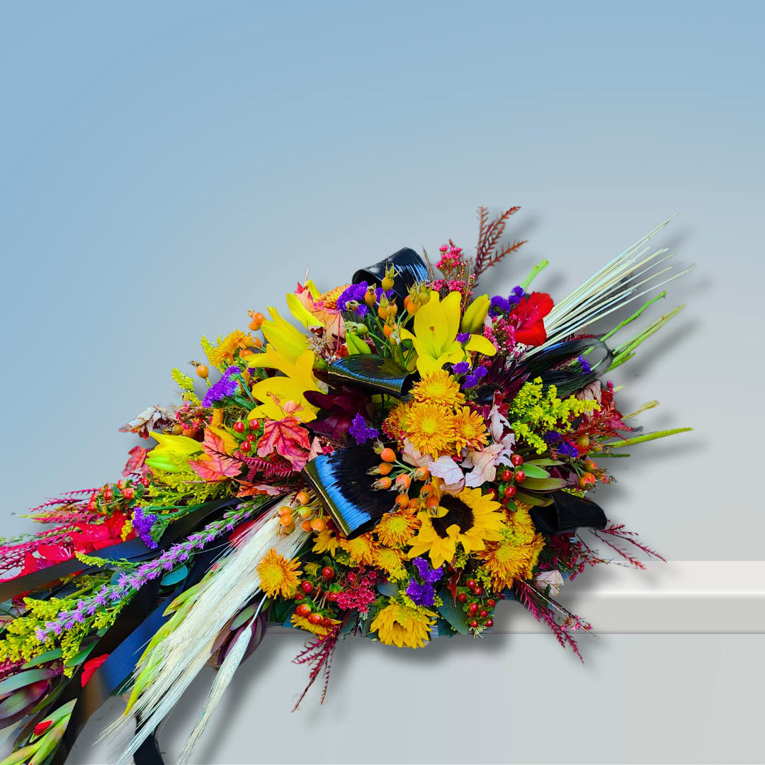 Fall Serenity Fall Serenity - Fall Serenity is a stunning sympathy floral tribute and an exclusive design from Specialty Floral Design. This heartfelt piece is crafted in a unique wrapped bouquet style, with flower stems artistically left exposed—giving the look and feel of a hand-tied bouquet lovingly laid across the casket. It’s a beautiful and natural approach to casket flowers, offering a sense of simplicity, warmth, and authenticity. This custom-designed arrangement features rich, seasonal blooms with a vibrant autumnal palette. We use a thoughtful mix of sunflowers, lilies, gladiolus, and solidago—bringing together the golden hues, warm oranges, and soft rusts that perfectly capture the spirit of fall. The result is a floral tribute that tells a story of a life well-lived, rich in love, beauty, and memory. Like many of our sympathy designs, Fall Serenity can be customized to reflect a more masculine or feminine style, depending on your preferences. While it’s especially fitting during the fall season, this wrapped bouquet-style casket piece can be recreated with seasonal flowers at any time of year. If you're searching for meaningful and personalized sympathy flowers, Specialty Floral Design is honored to be your local florist in Olympia, WA. We specialize in one-of-a-kind funeral arrangements that are created with care and attention to every detail. Let us help you express love, honor, and remembrance through flowers that speak from the heart.