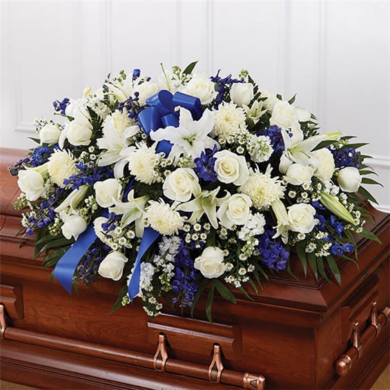 Blue &amp; White Mixed Half Casket Cover - Honor a life so beautifully lived with a proud display of blue and white blooms. Our half casket cover, crafted with care and artistry by our expert florists with blue delphinium, white roses, and accented with a blue satin ribbon, is an unforgettable way to commemorate a lifetime of loving devotion. Please give us at last 24 hours for this one. Please specify in Special instruction section if you prefer different colors of flowers.