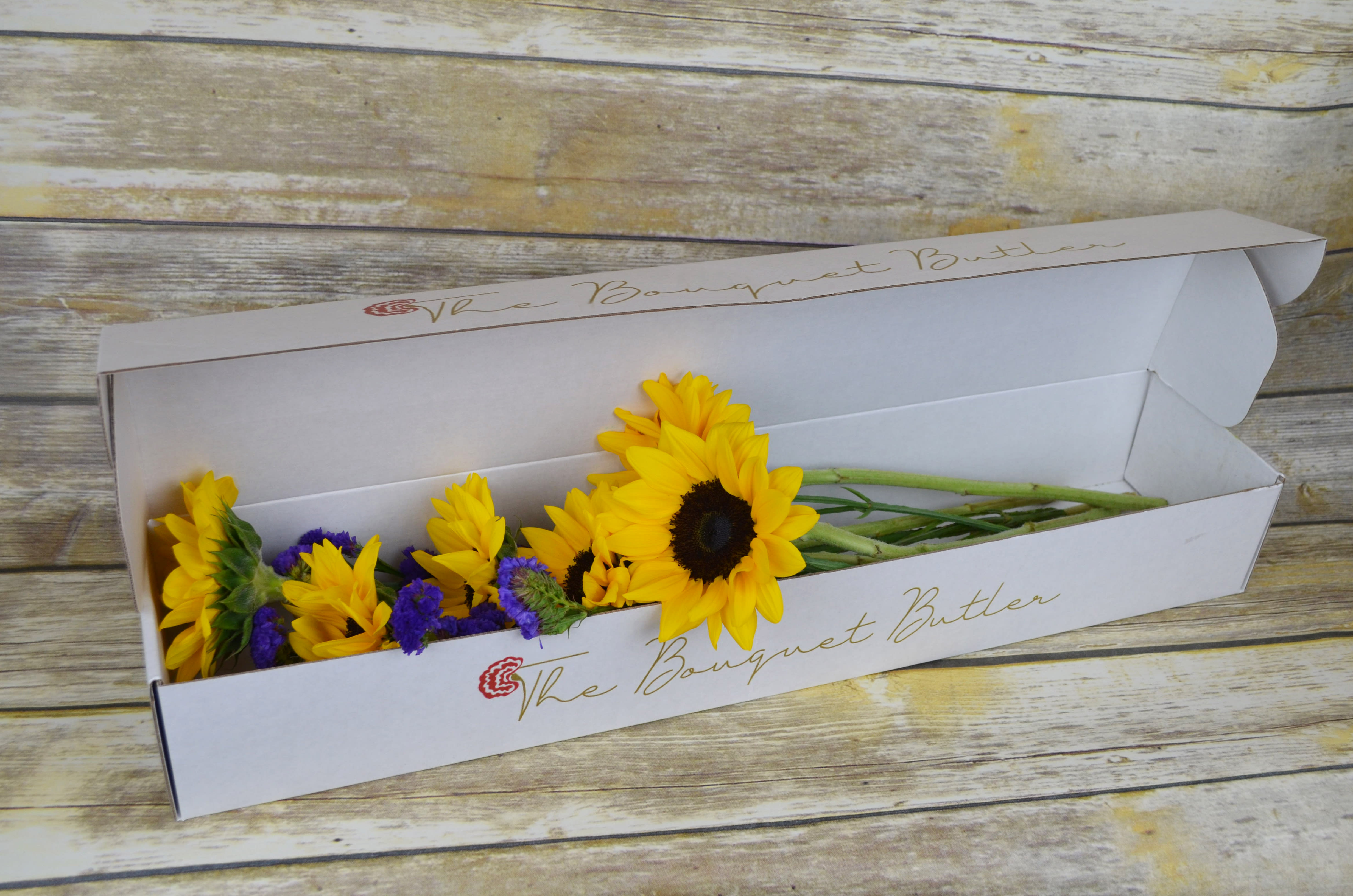 Sunset Sherbet - Boxed - Just the right touch for all you sunflower lovers out there. All bouquets are arranged by our professional floral design team accented with seasonal filler (i.e. greenery, baby’s breath, etc.) inside a gift box. Blooms are hand delivered in person to enhance any celebration or a “just because” surprise.