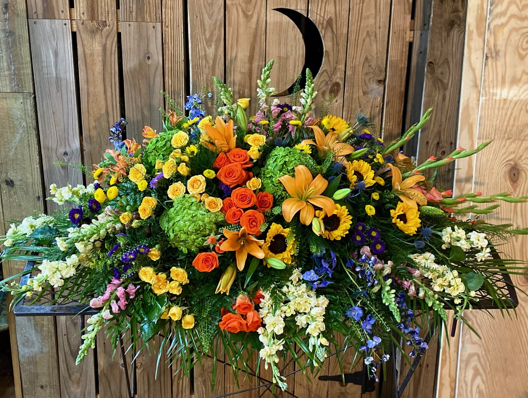 Rainbow Reflections Casket Spray Rainbow Reflections Casket Spray - This colorful casket spray celebrates a bright life with the natural beauty of hydrangea, roses, lilies and sunflowers.