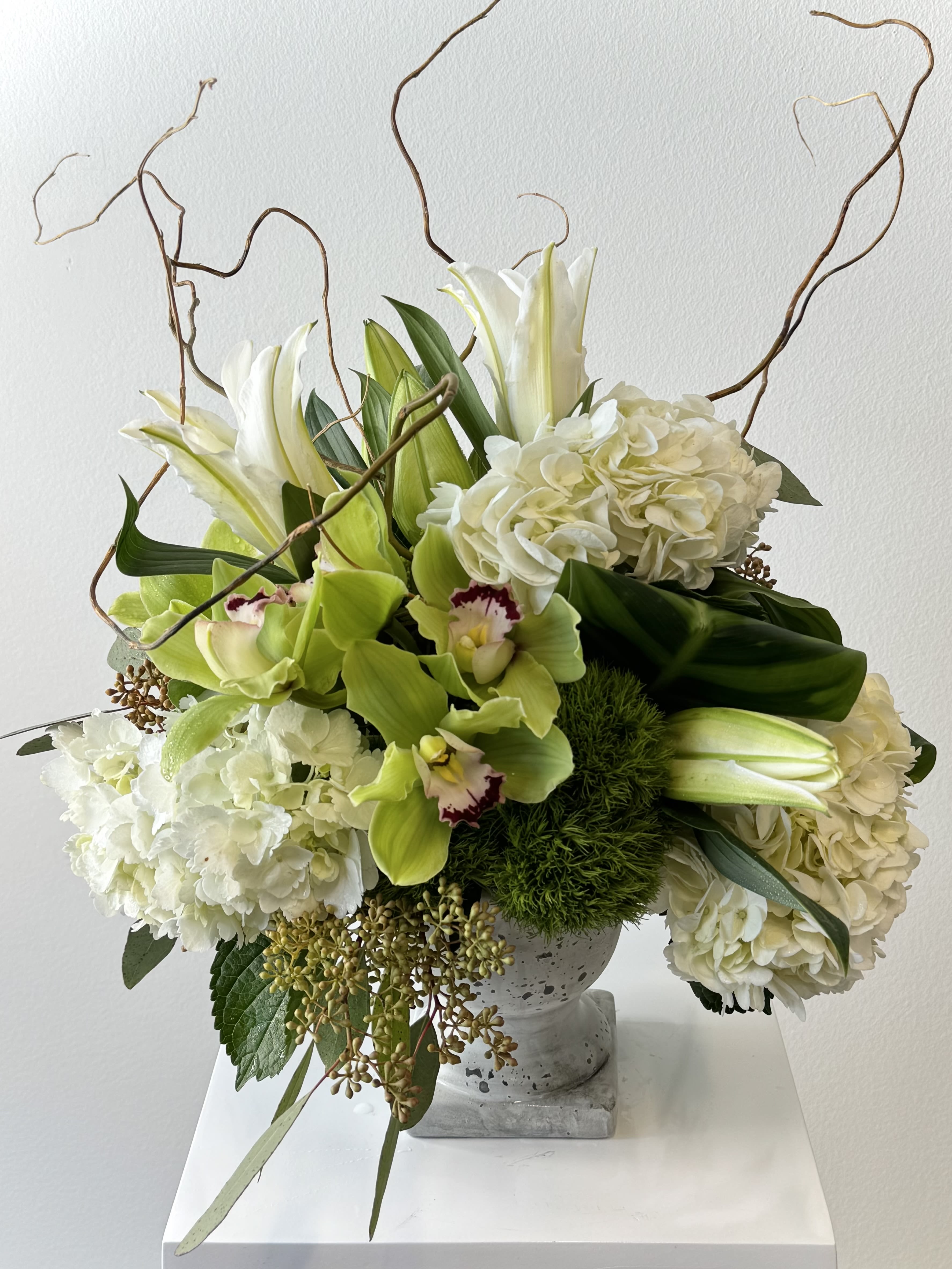 Hey Jade - This green and white modern design is made with white hydrangea, white asiatic lilies, green cymbidium orchids, green ball trick and curly willow and lush green foliage.