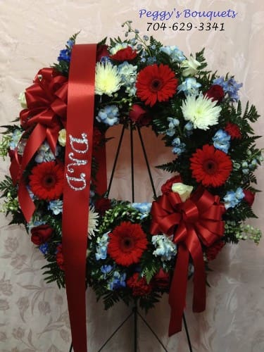 A Child's Sorrow A Child's Sorrow - Red gerbera daisies, red roses, blue delphinium, white spider mums and white roses make a beautiful tribute to a loved one who served in the military.