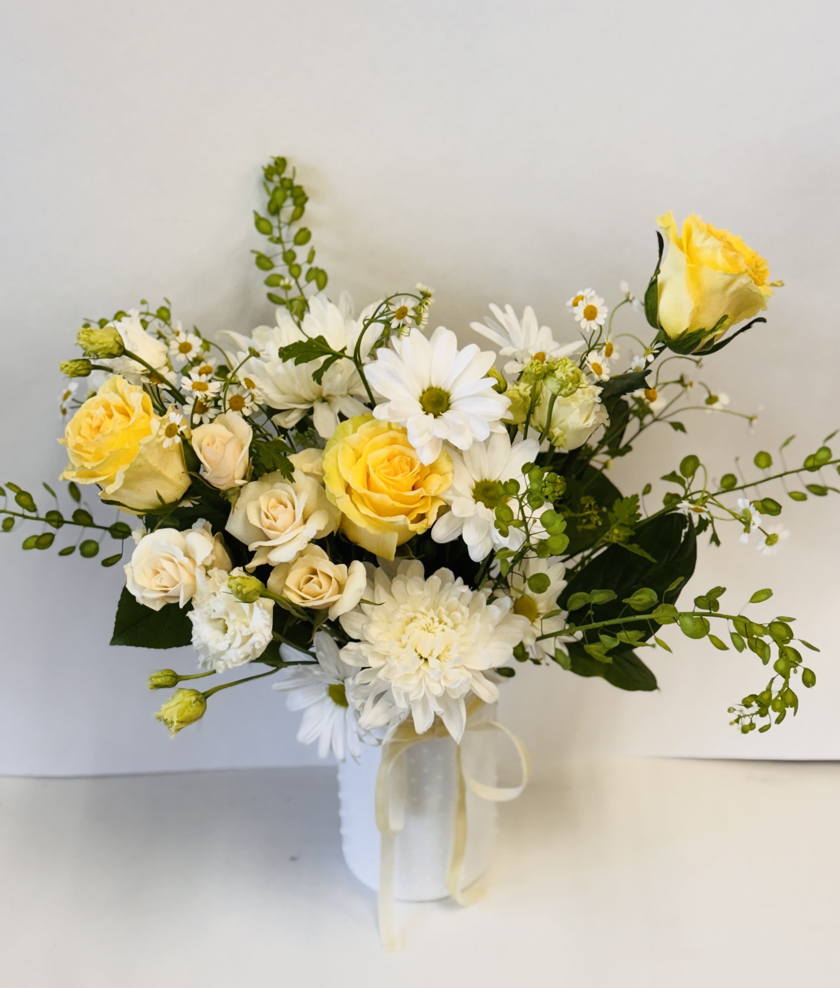 Sunlit Grace - Photo is a representation.  This arrangement has a soft, elegant feel with its mix of white and yellow blooms.  We will select the best blooms available in this color palette. 