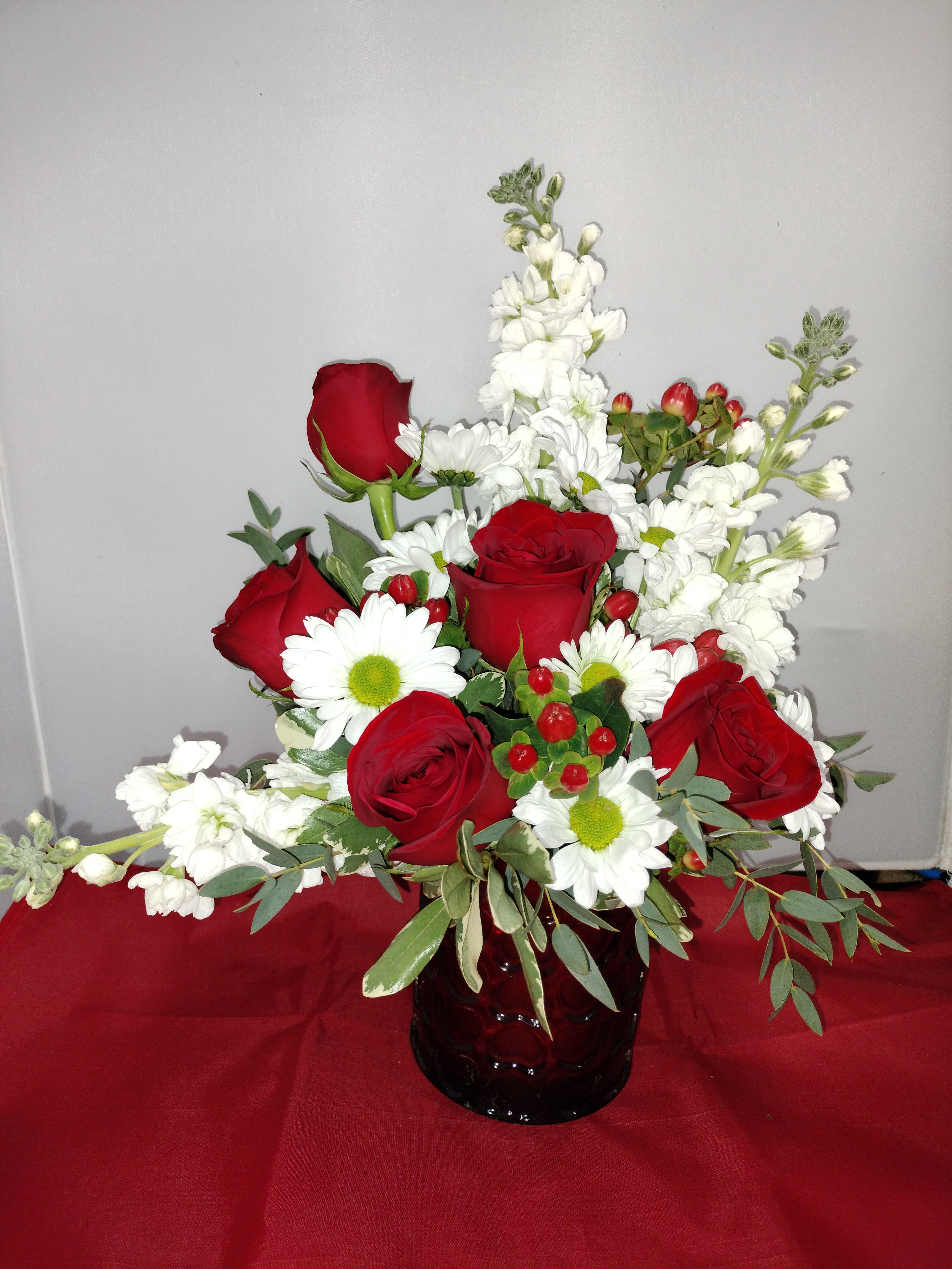 Sending You My Heart in Red Glass Embossed Heart Cylinder Vase - This heart embossed vase sports Red Roses, White Stock, White Daisies and Red Hypericum and mixed greenery.