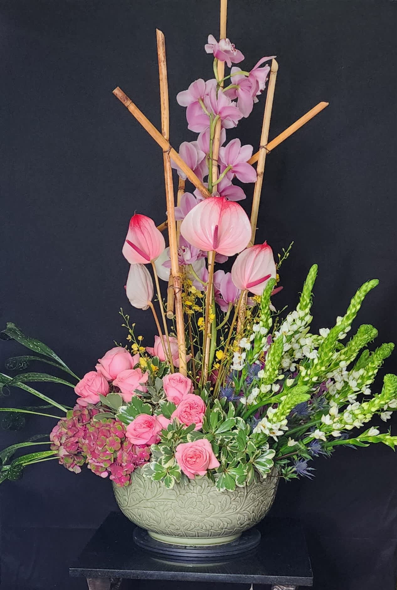 Cymbiduim Centerpiece - Beautifully curated, large centerpiece.  You could definitely call this one a showstopper with cymbidium, antherium, roses, hydrangeas, blue thistle and bamboo. 
