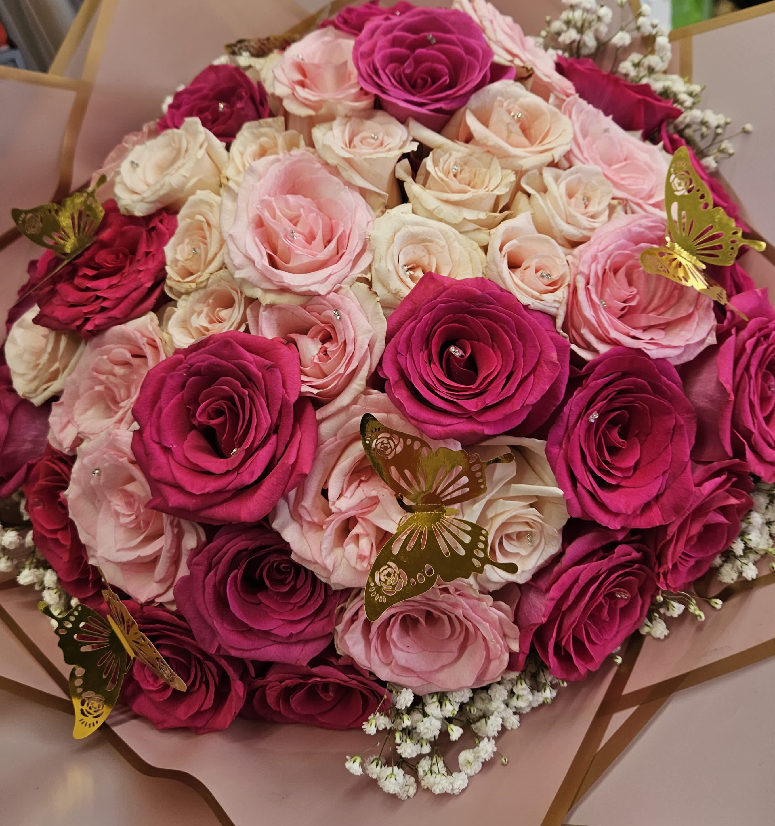 Pink Buchon Pink Buchon - it is made with: 24 hot pink roses 24 light pink roses 6 golden butterflies 4 baby breath wrapped with pink paper.