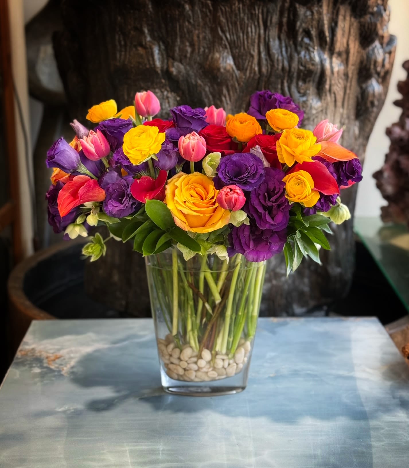 Virginia  - Premium Roses, Lisianthus, Tulips, Ranunculus, and more in glass vase and white rock.