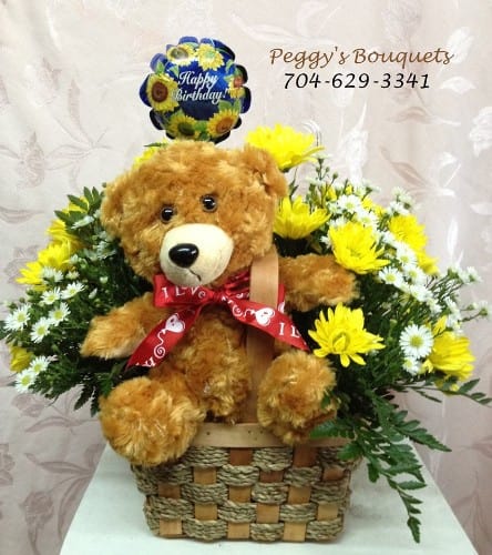 A Child's Birthday A Child's Birthday - A plush bear adorns this basket full of daisies and monte casino. The gift is complete with a small balloon. Perfect for any birthday.