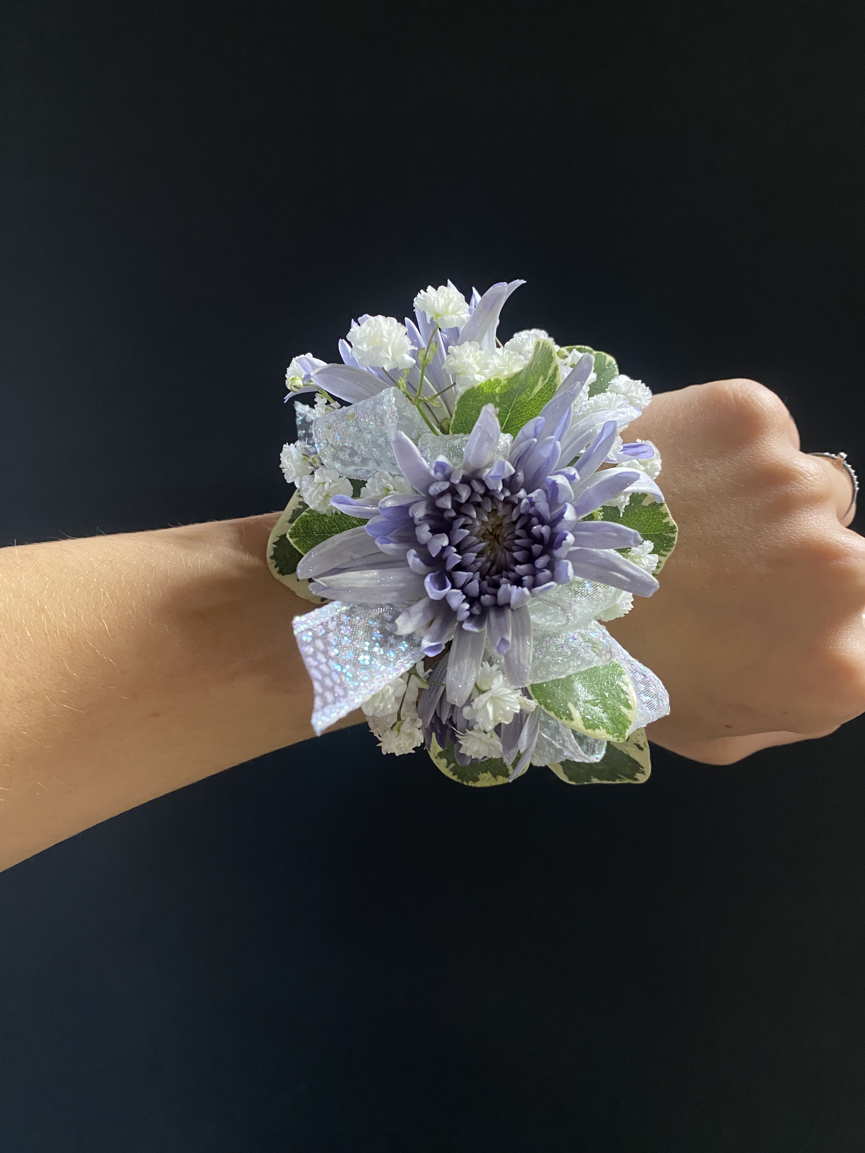 ocean spray corsage - blue cushion daisies with variegated pit, babies breath and iridescent ribbon. When choosing, know that we will also keep the same overall look and color scheme, however, each piece will be unique in its own way.