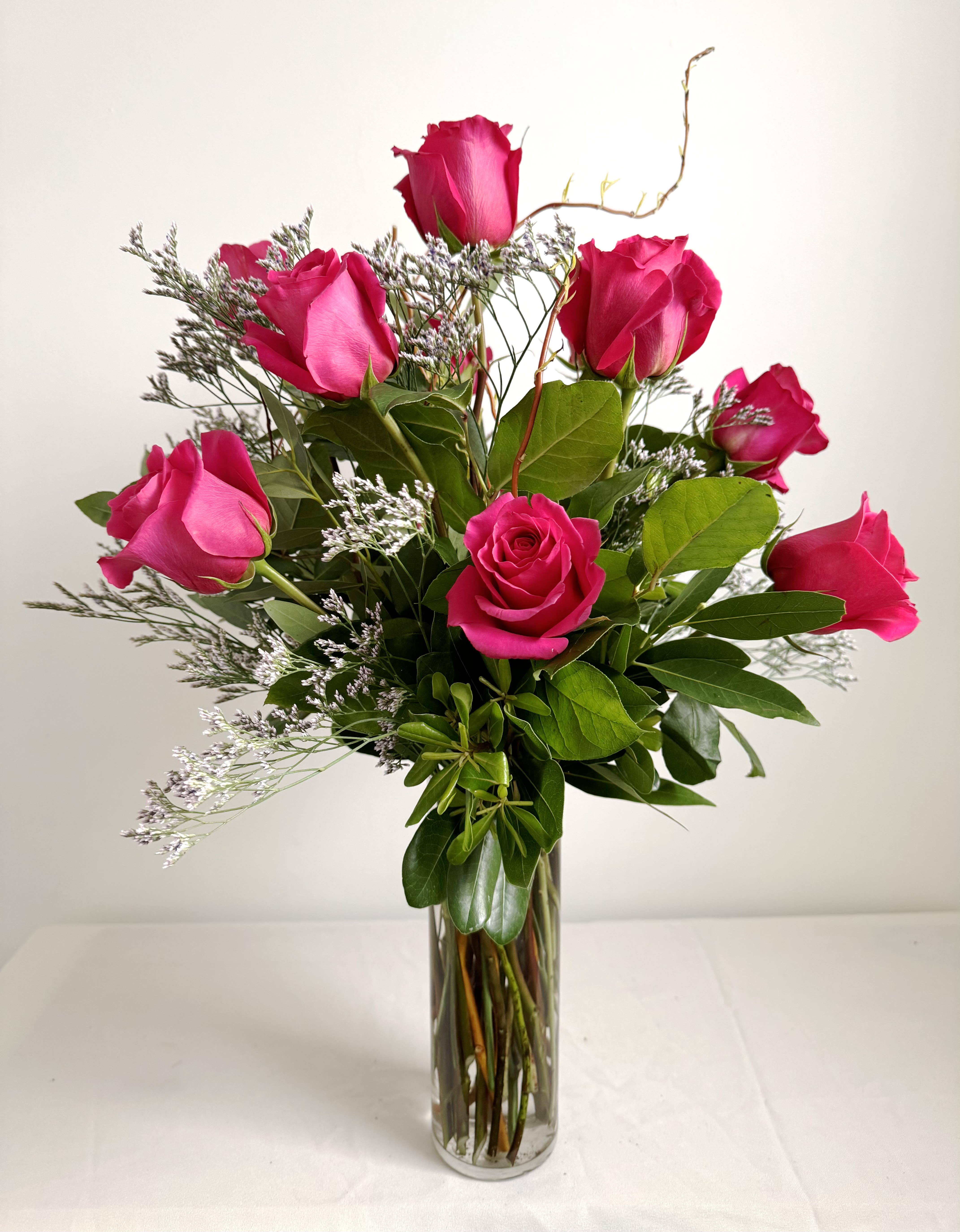 Pink Rose Arrangement  - Standard price is- One dozen roses Deluxe Price is- Two dozen roses Premium Price is- Three dozen roses Hot pink roses are arranged in a tall cylinder vase with greens and filler.  Delivery Info- We make all of our deliveries after 1pm every day. If the weather is very cold, we prefer not to leave the flowers outside. Please let the recipient know that they should expect delivery.